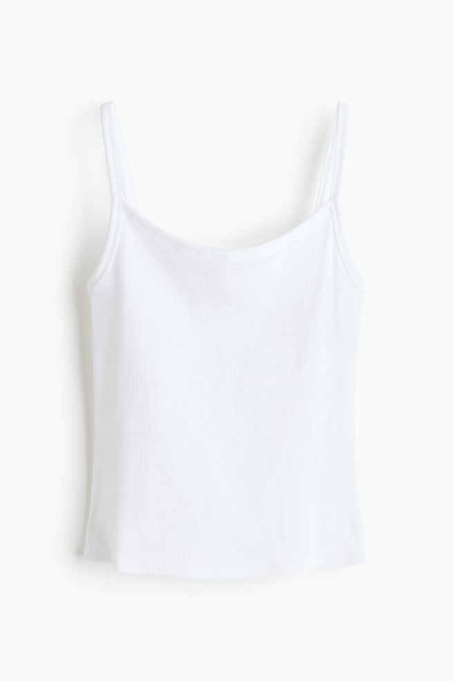 A white ribbed knit camisole is displaying a front view, featuring thin spaghetti straps, a rounded neckline, and a straight hem. - 1