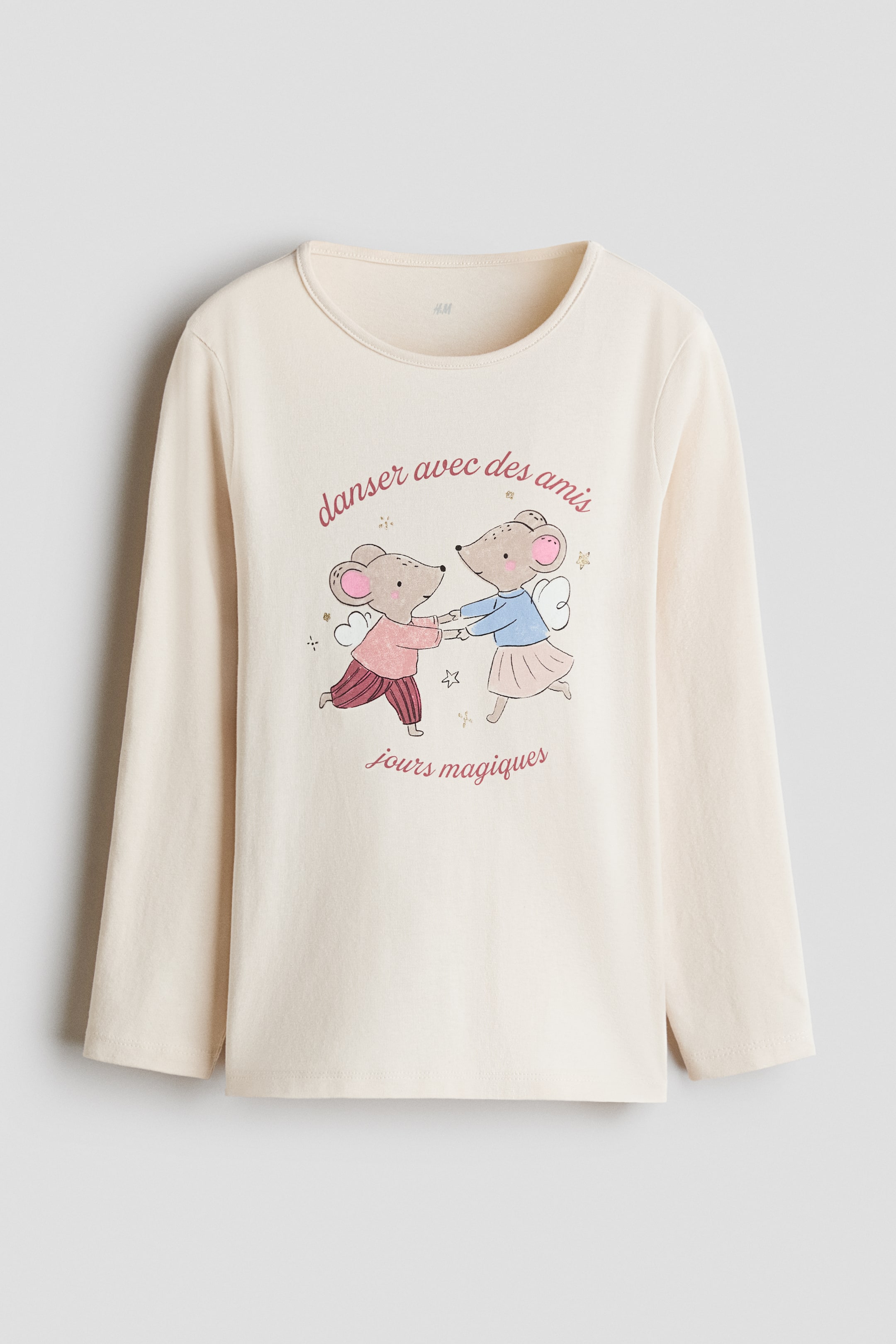 View larger image: A cream-coloured cotton jersey long-sleeve top is shown from the front, featuring a round neckline with a narrow trim. A graphic print adorns the chest, depicting two cartoon mice dancing, with French text 'danser avec des amis' above and 'jours magiques' below.