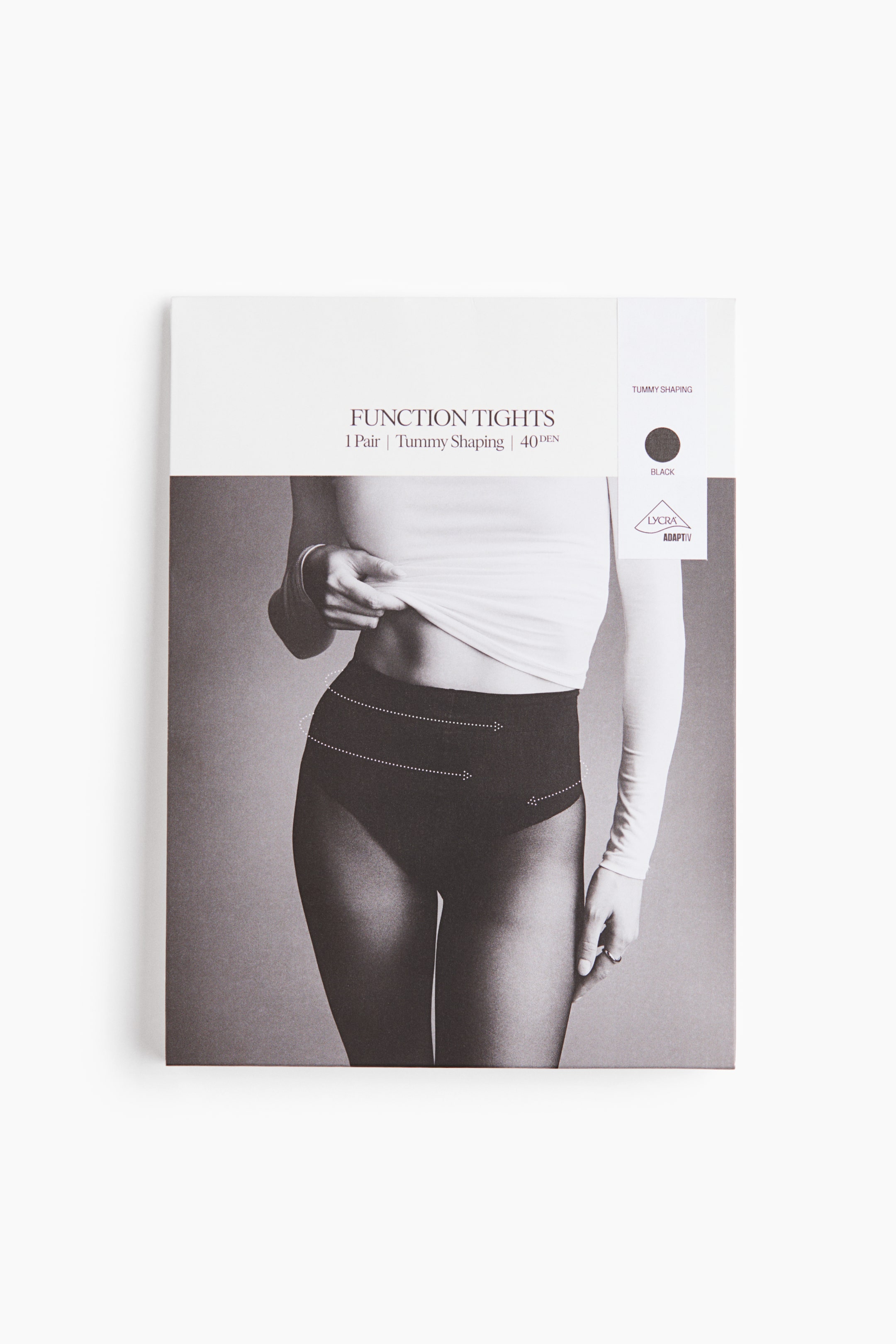 Zobacz większy obraz: Prostokątne opakowanie Function Tights jest skierowane przodem i ma białą górną sekcję z napisem „Function Tights | 1 Pair | Tummy Shaping | 40 DEN” oraz czarną próbkę koloru, a poniżej znajduje się obraz w skali szarości przedstawiający osobę w czarnych rajstopach z kropkowanymi liniami ilustrującymi modelowanie brzucha.