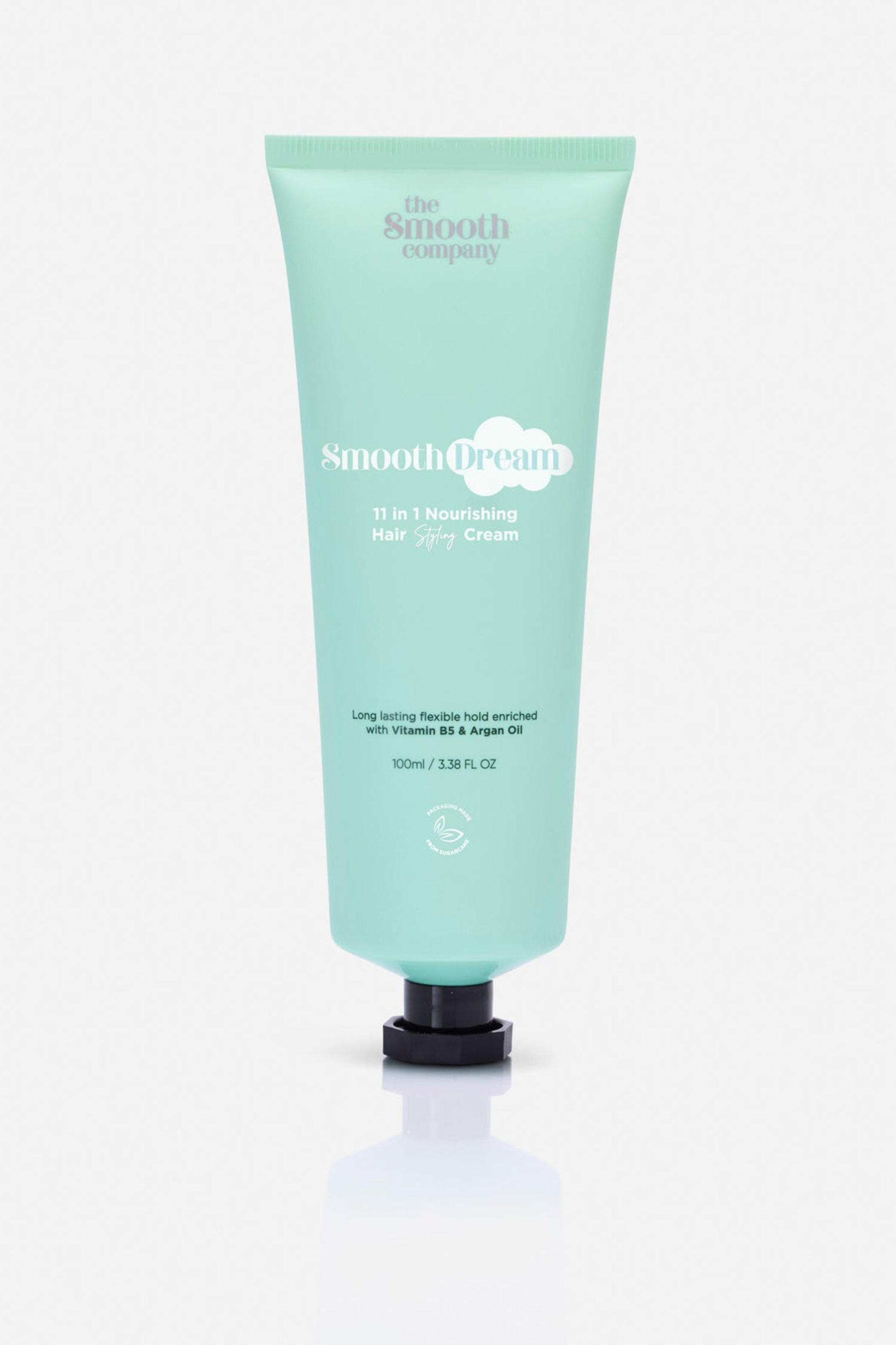 Vis større bilde: Et mintgrønt hårstylingkremrør står oppreist, vendt fremover. Røret har "the Smooth company"-merkevaren øverst, og "Smooth Dream" i hvit tekst med et sky-design, etterfulgt av "11 in 1 Nourishing Hair Styling Cream," som viser produktdetaljer inkludert volum, og er forseglet med et svart, sekskantet lokk.