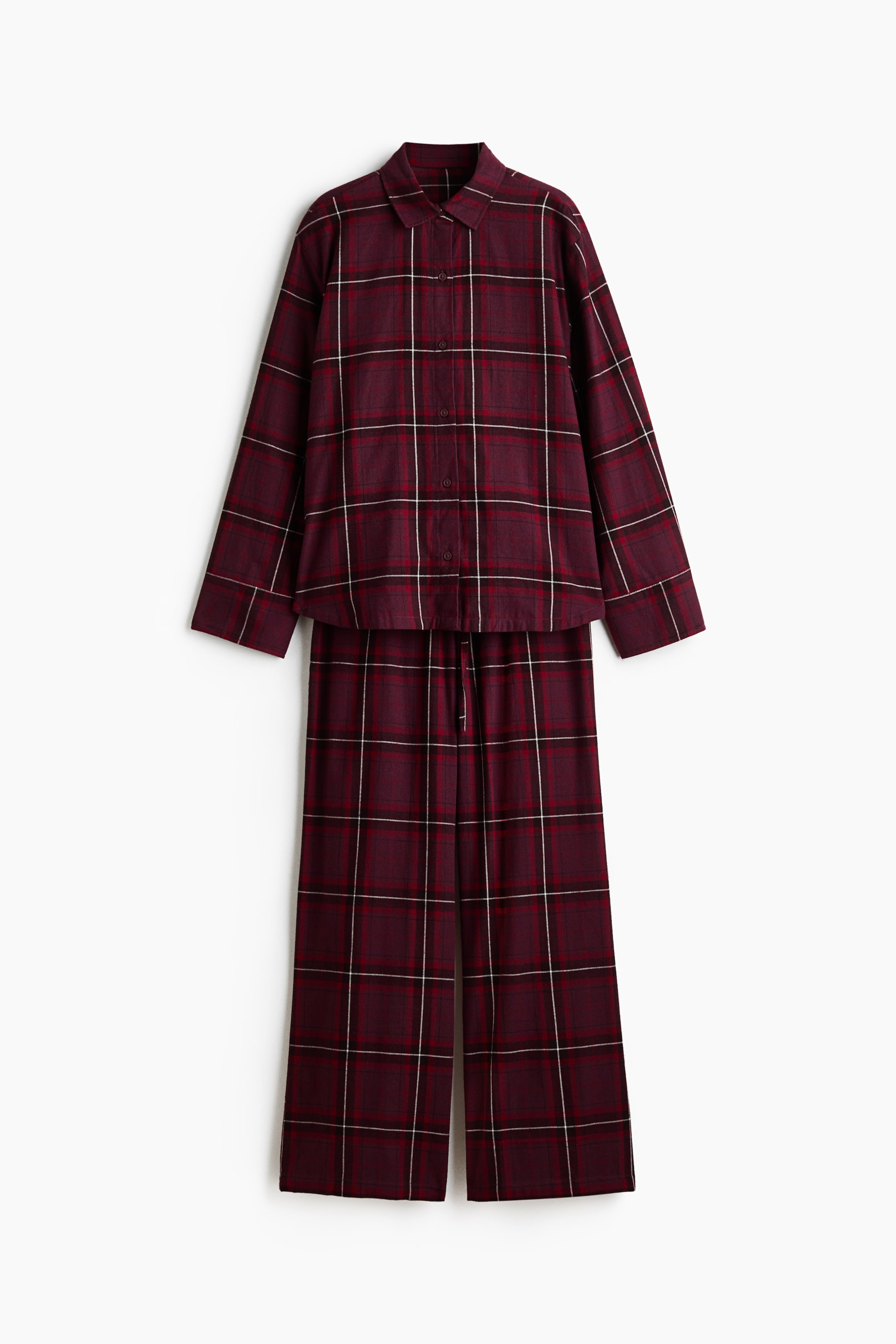 Visualizza l'immagine ingrandita: Un pigiama in due pezzi presenta un motivo a quadri color bordeaux con linee rosse, nere e bianche. La camicia a maniche lunghe ha un colletto a punta e una chiusura frontale con bottoni su tutta la lunghezza, mentre i pantaloni lunghi coordinati presentano un elastico in vita con coulisse.