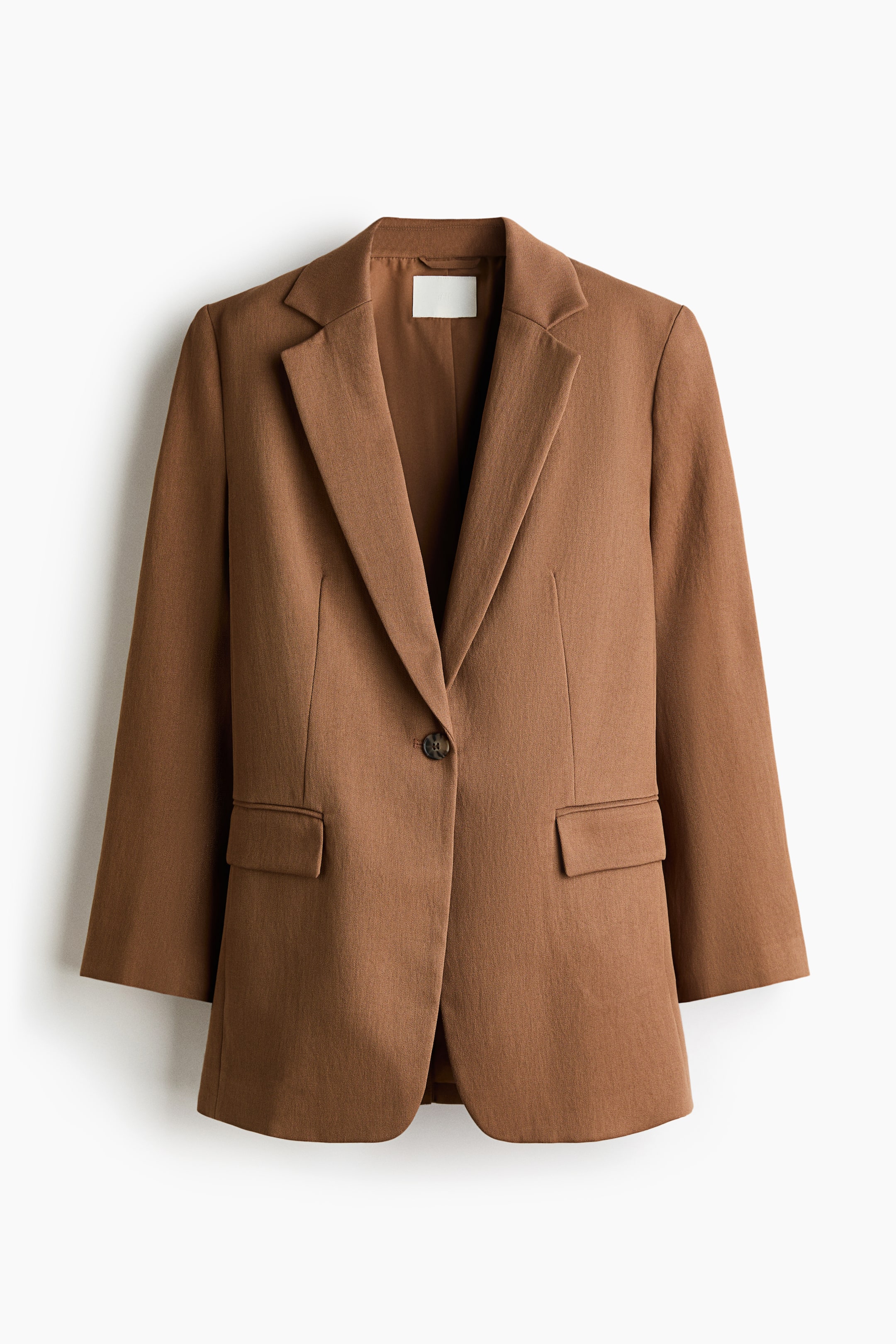 Größeres Bild anzeigen: Ein brauner, einreihiger Blazer aus gewebtem Stoff zeigt seine Vorderseite, mit Kerbrevers und Schulterpolstern. Er wird vorne mit einem Knopf geschlossen und verfügt über zwei paspelierte Taschen mit Klappen, wirkt gefüttert.