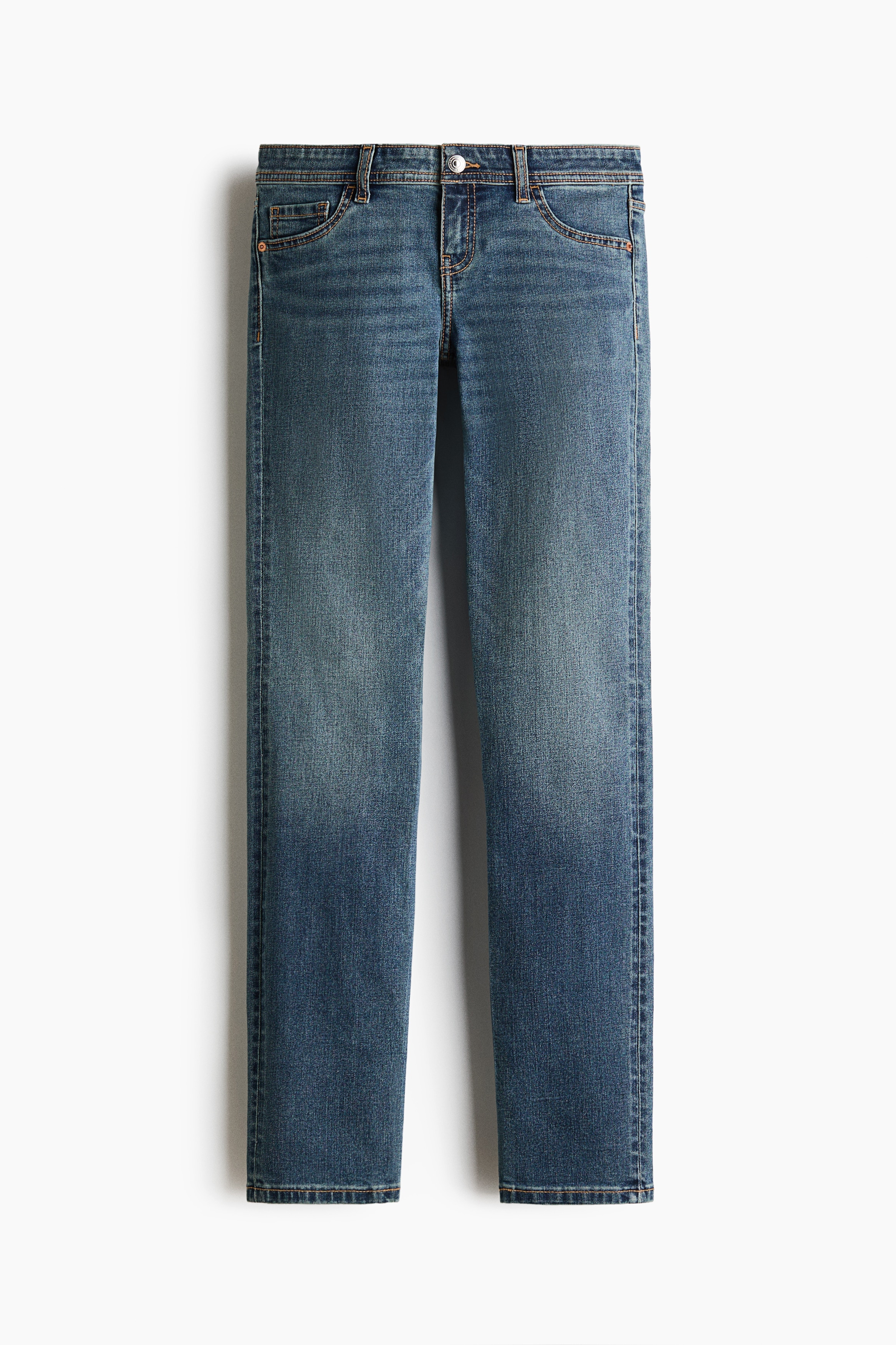 Model ma na sobie niebieskie jeansy z denimu z bardzo niskim stanem, wÄskim krojem i imitacjÄ kieszeni z przodu. Jeansy zestawiono z niebieskim topem z dÅugim rÄkawem, krÃ³tkÄ czarnÄ kurtkÄ i czarnymi sneakersami.