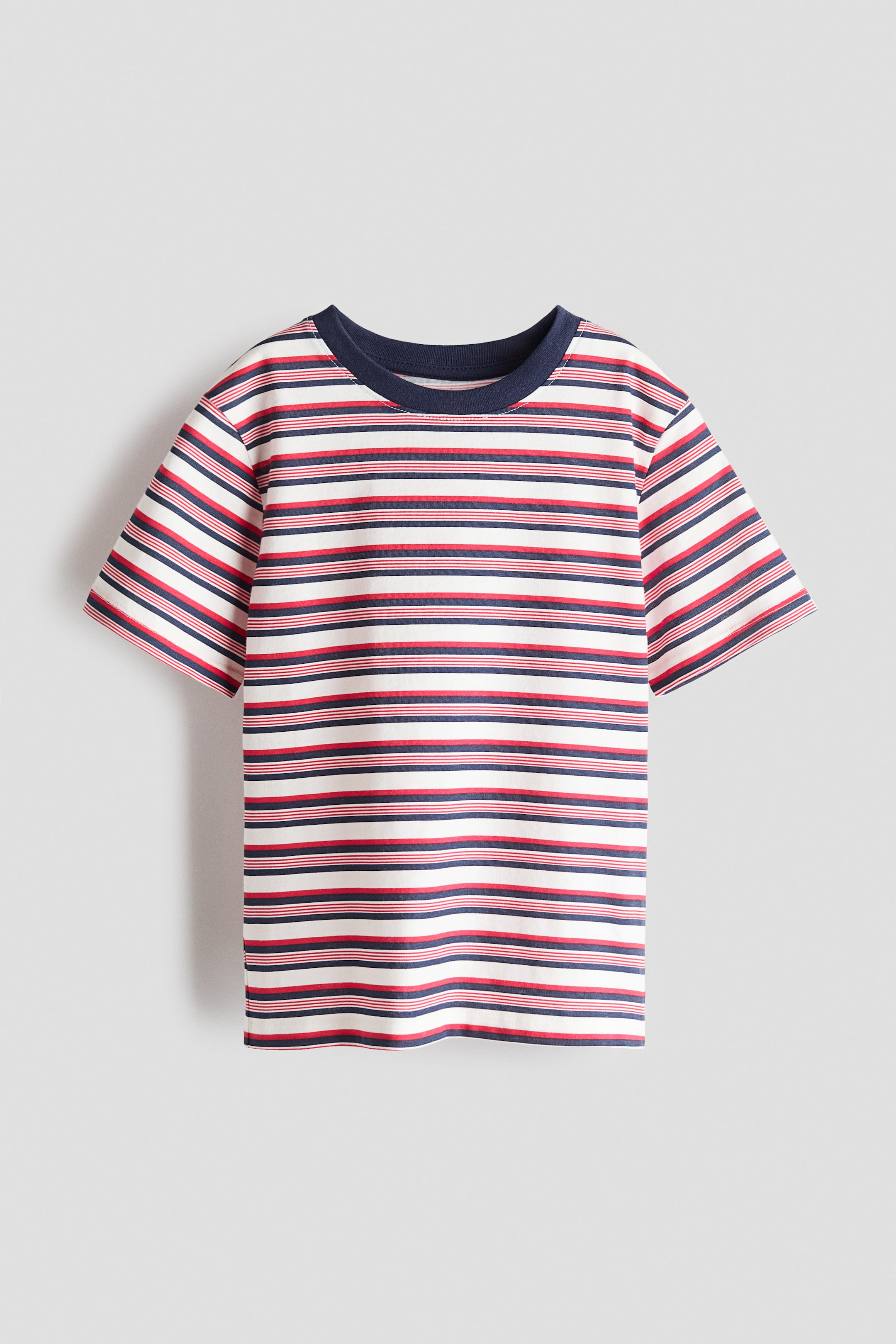 View larger image: A T-shirt is displaying its front, presenting a pattern of thin red and navy blue horizontal stripes on a white background. A navy blue ribbed trim is finishing the round neckline, and short sleeves are extending from the shoulders.