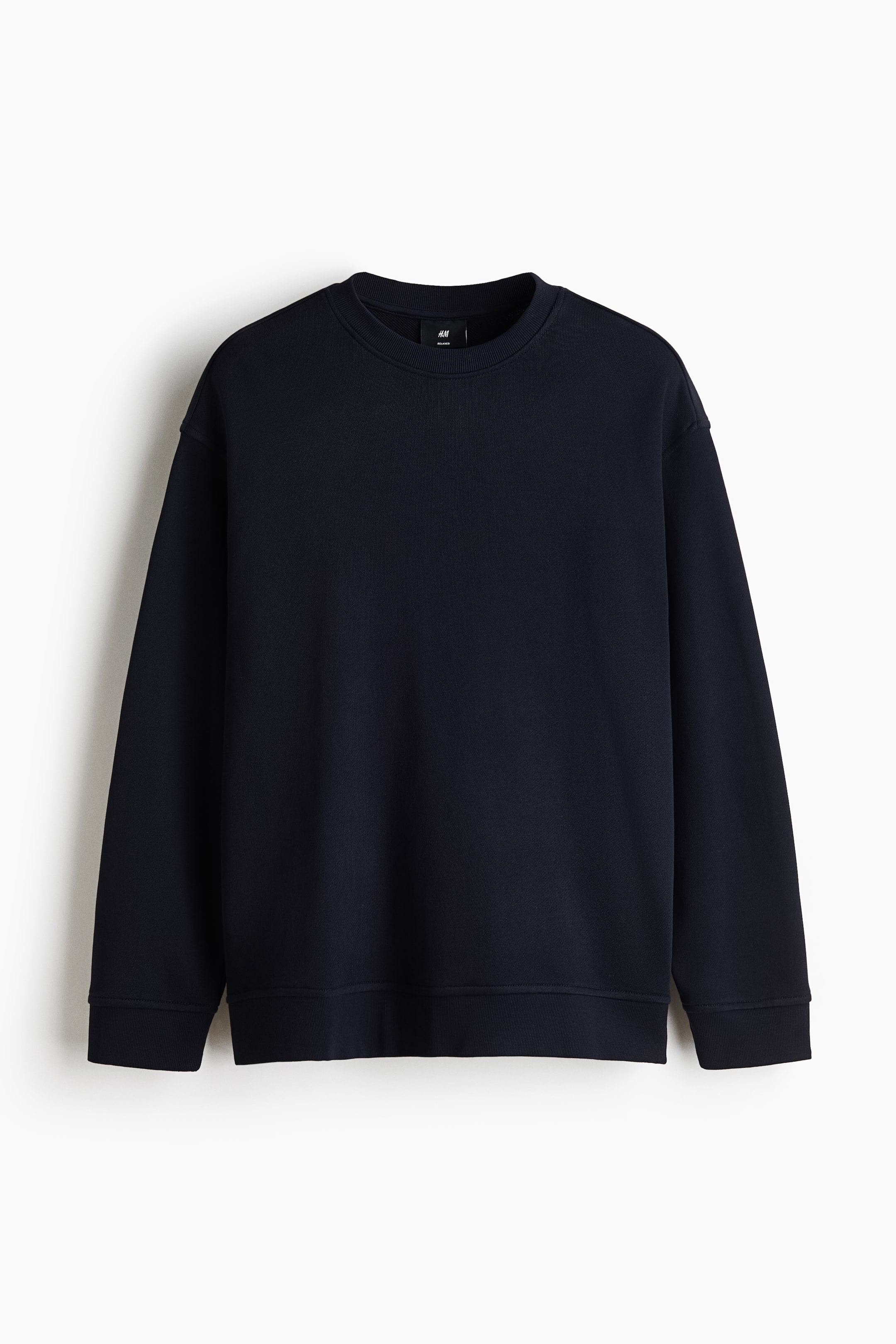 View larger image: A dark blue sweater is shown from the front with a relaxed fit, featuring a round rib-trimmed neckline, dropped shoulders, long sleeves, and wide ribbed trims at the cuffs and hem.