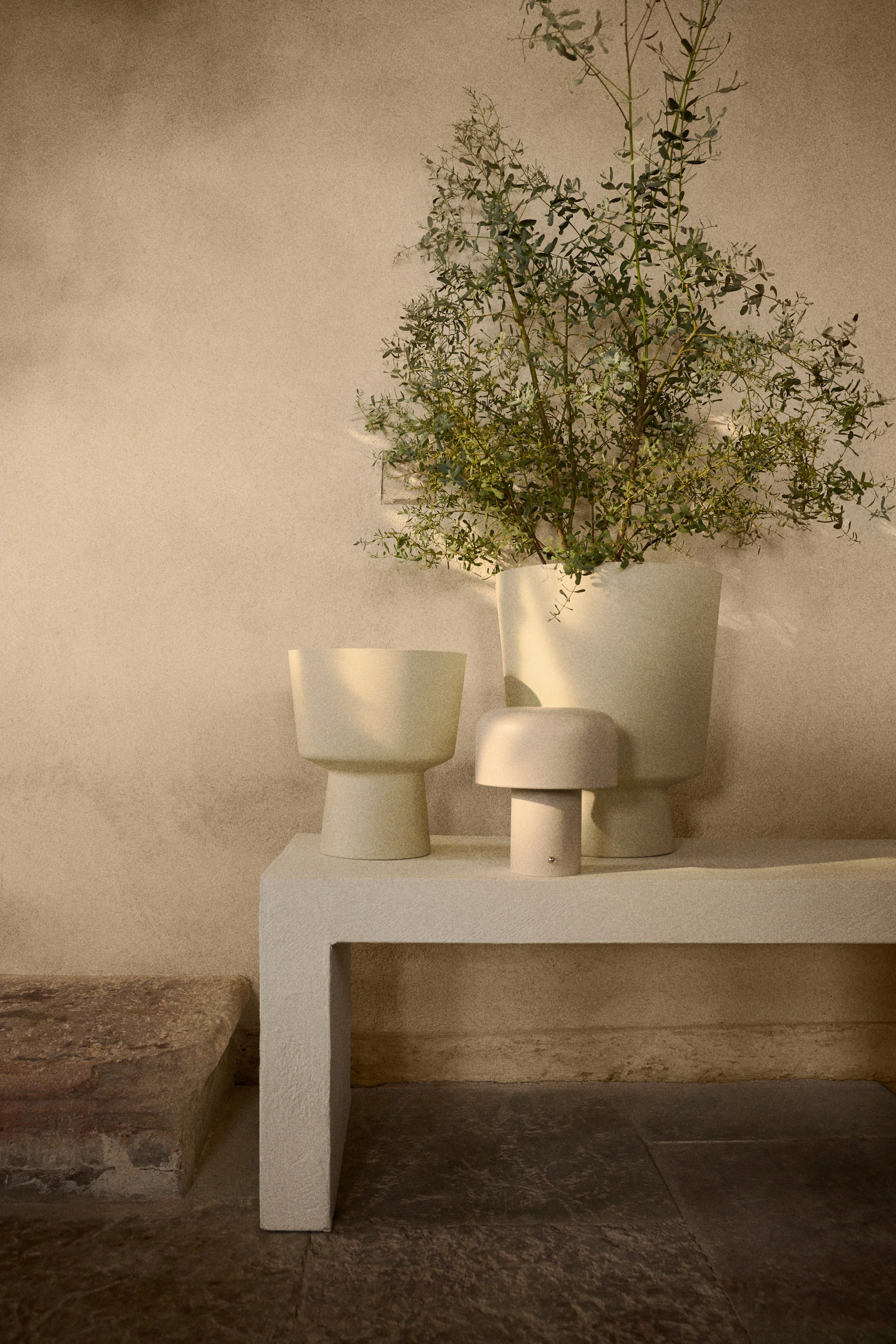 View larger image: A spacious plant pot is showcased as a light-toned, painted metal vessel, highlighting a broad, open top and an inverted trapezoidal shape that tapers down to a distinct, cylindrical base. It is crafted with a drainage hole at the bottom and is ideal for both indoor and outdoor settings.