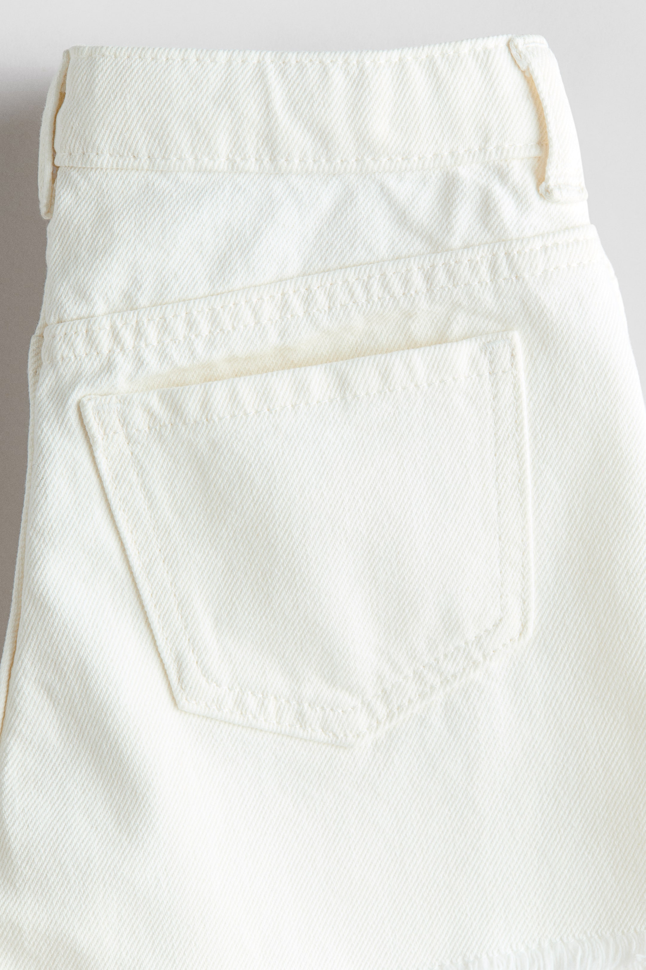 Short frangé en denim