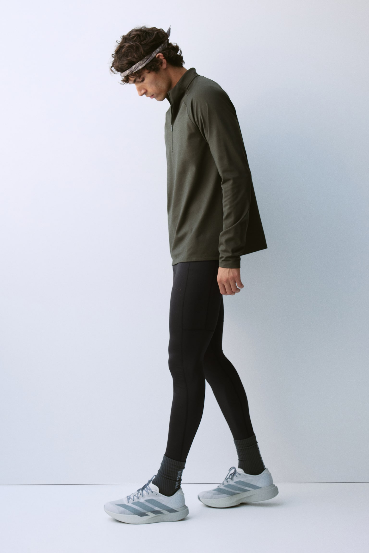 These black leggings are presenting from the front, featuring a wide waistband and visible flatlock seams running down the sides. A small, rectangular pocket is visible on the upper left side, with a similar pocket appearing on the upper right side, and a subtle "MOVE" logo is marking the right thigh. - 1
