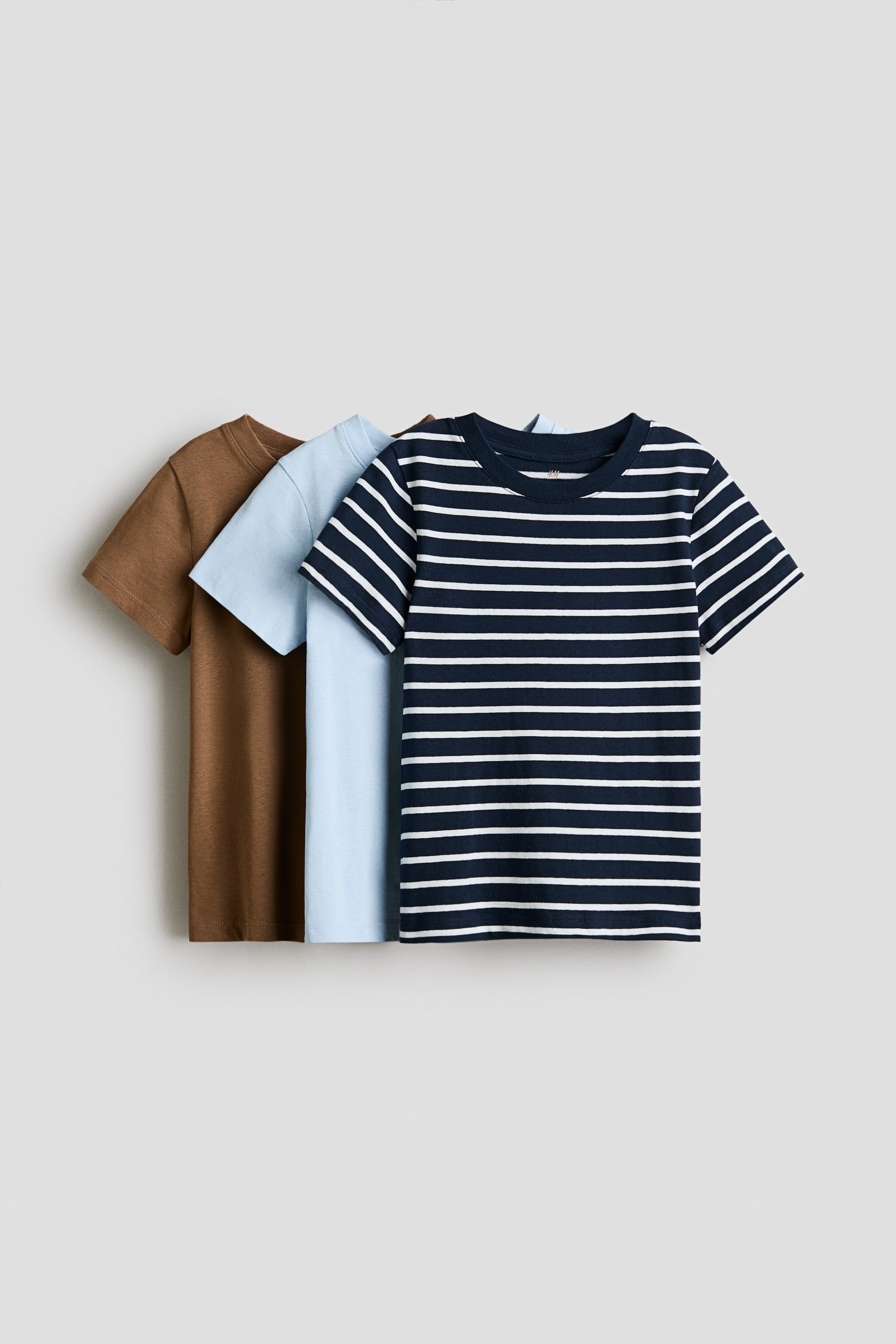 View larger image: The back t-shirt is brown, the middle t-shirt is light blue, and the front t-shirt is dark blue with thin white horizontal stripes.
