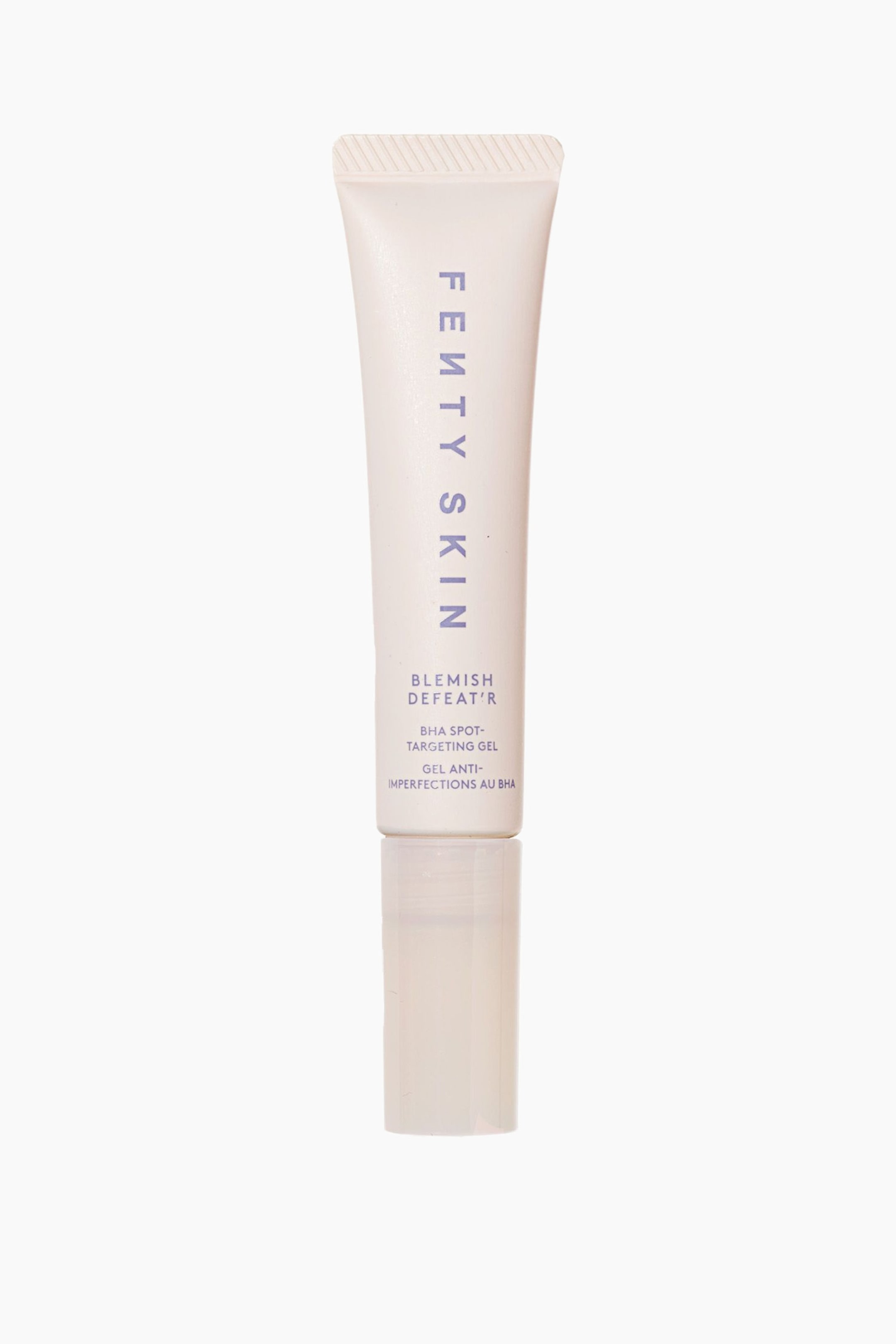 Visa större bild: En tub med Fenty Skin Blemish Defeat'r BHA Spot-Targeting Gel står upprätt och vänd framåt. Produkten har en ljusrosa klämtub med lila text och vilar på ett klart, genomskinligt cylindriskt lock.