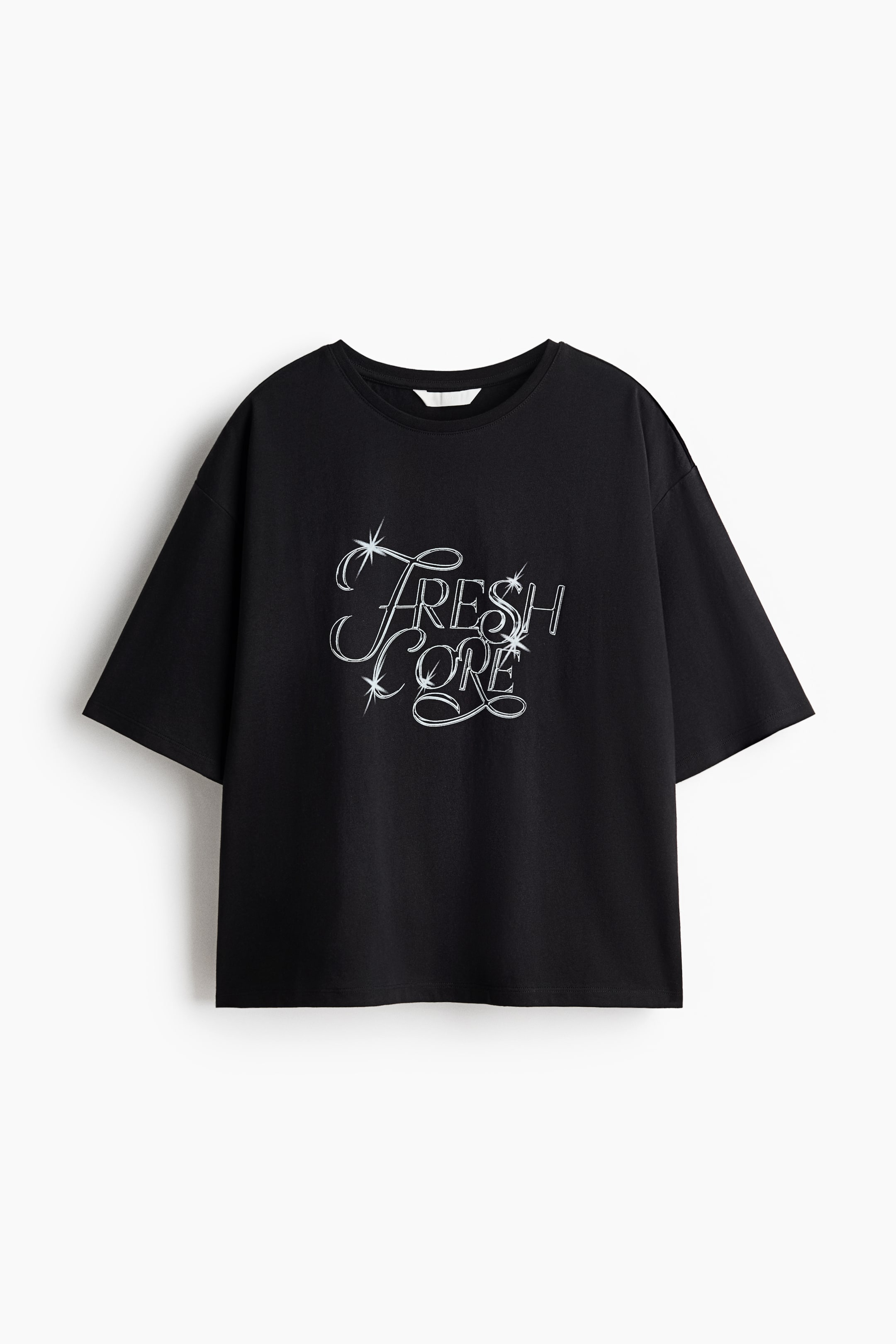 拡大画像を表示: 黒いTシャツが正面を向いており、丸いネックラインと短く広い袖が特徴です。胸元には、星のアクセントが付いた「Fresh Core」という白いスタイライズドテキストグラフィックが表示されています。