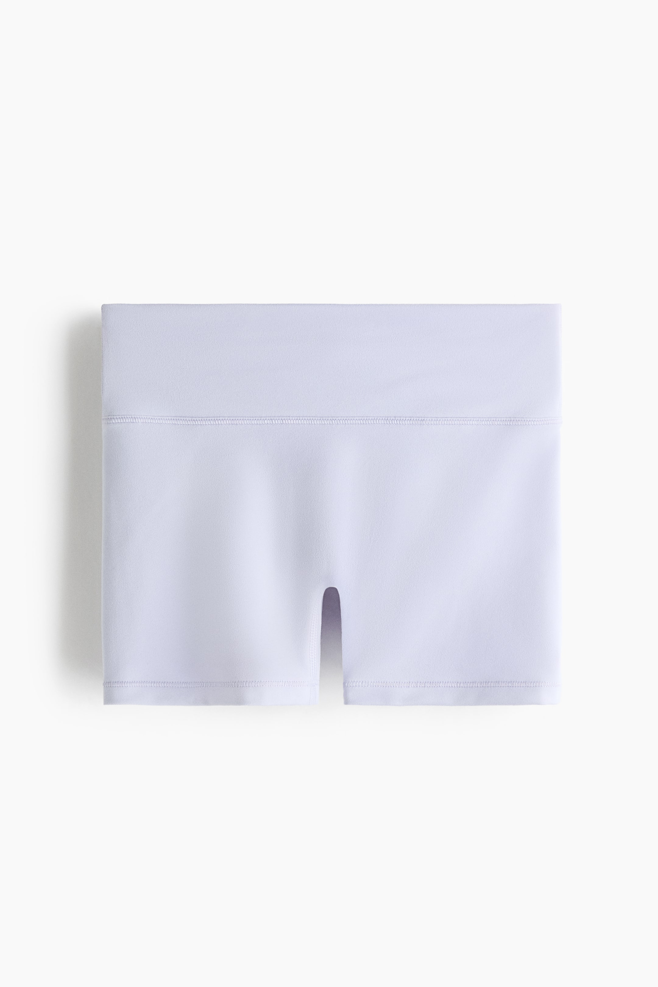 View larger image: Light purple sports hotpants are showcased flat from the front, featuring a wide waistband with a visible horizontal seam and a small vertical slit at the center bottom hem.