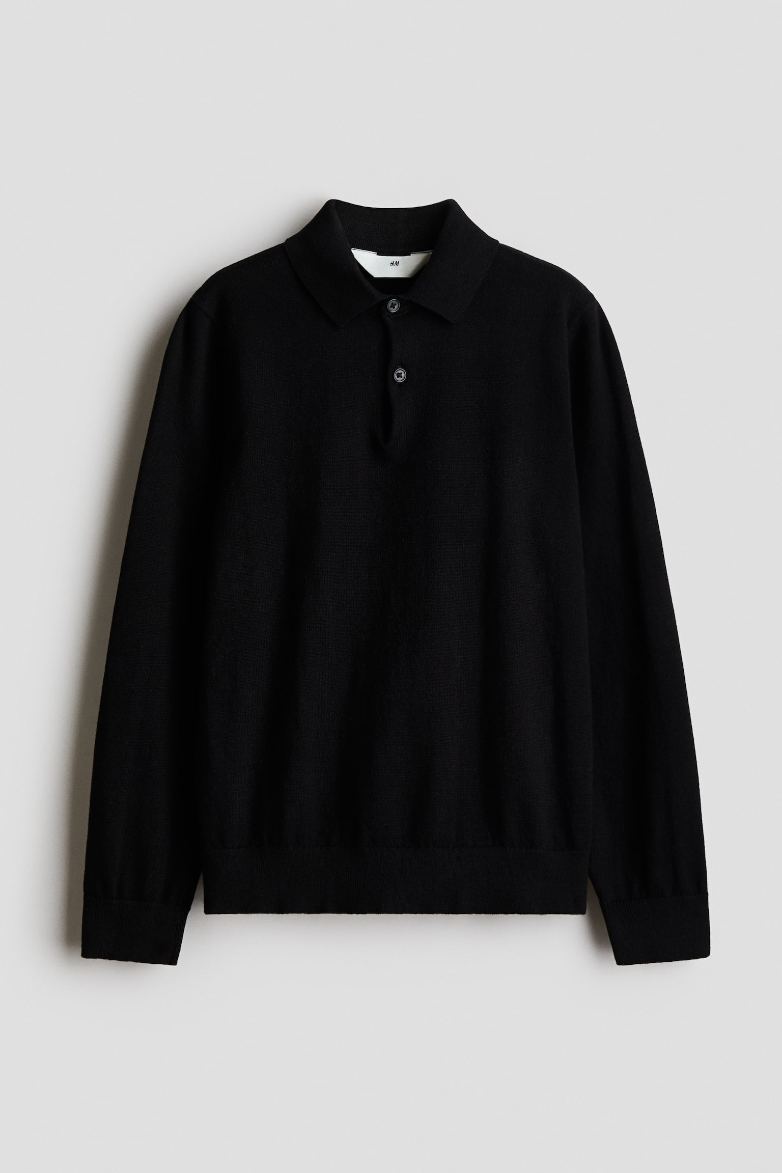 Ein schwarzer Strick-Polopullover mit langen Ãrmeln ist frontal ausgerichtet und verfÃ¼gt Ã¼ber einen klassischen Kragen, eine Zweiknopfleiste sowie gerippte ÃrmelbÃ¼ndchen und einen gerippten Saum.