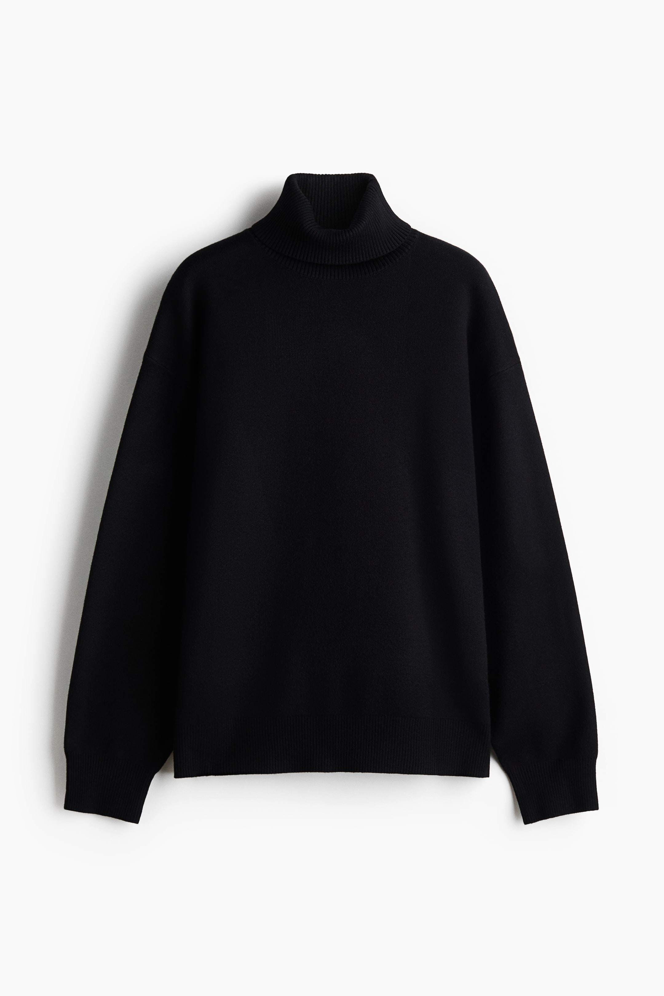 Größeres Bild ansehen: Ein schwarzer, oversized gestrickter Pullover ist von vorne zu sehen und zeigt einen gerippten Rollkragen, überschnittene Schultern und lange Ärmel. Feine Rippdetails an den Bündchen und am Saum betonen seine lockere und bequeme Silhouette.