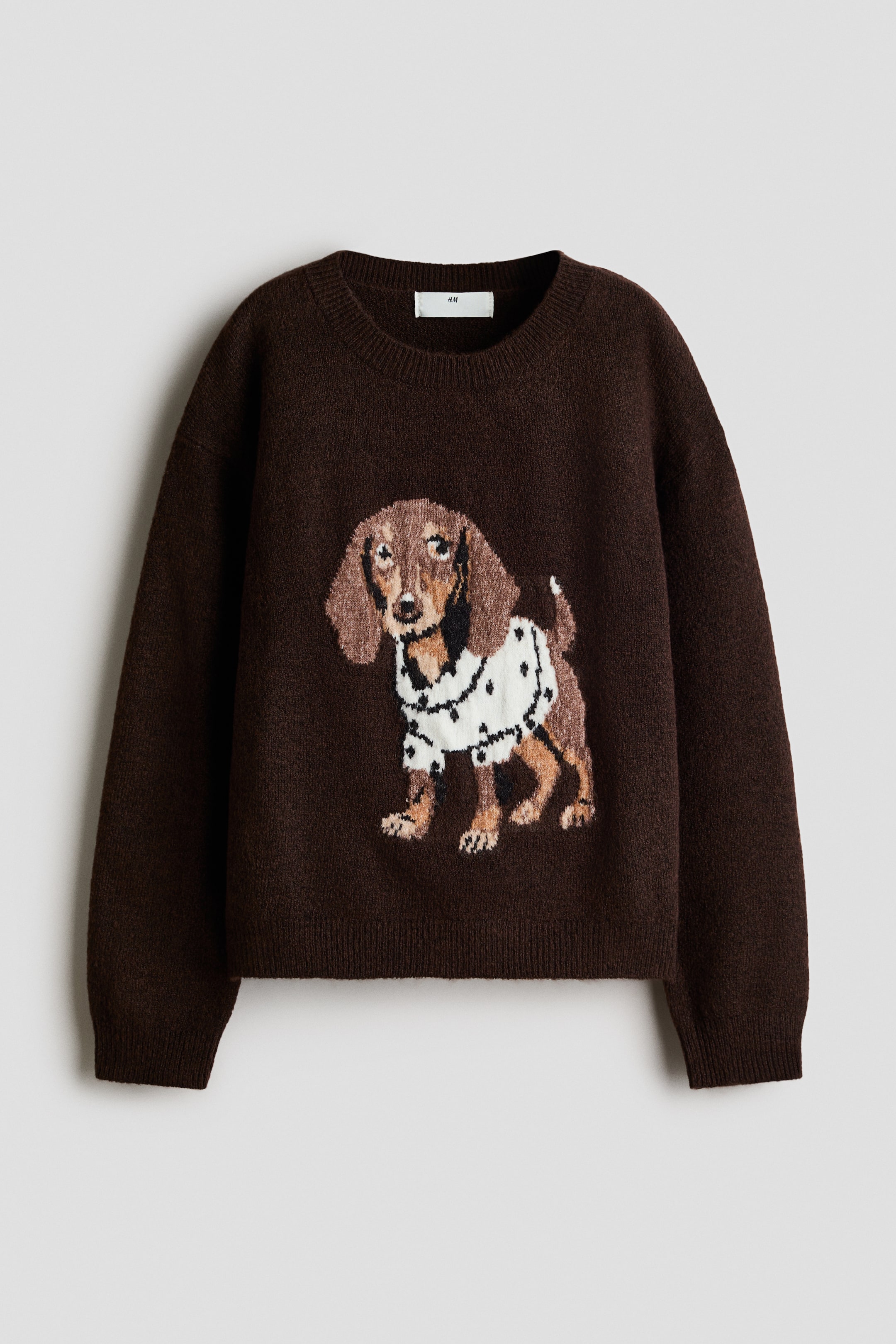 View larger image: The front of a loose-fit brown jumper in a soft knit features a dachshund motif wearing a white polka-dotted jumper. It has a round, rib-trimmed neckline, dropped shoulders, and ribbed cuffs and hem.