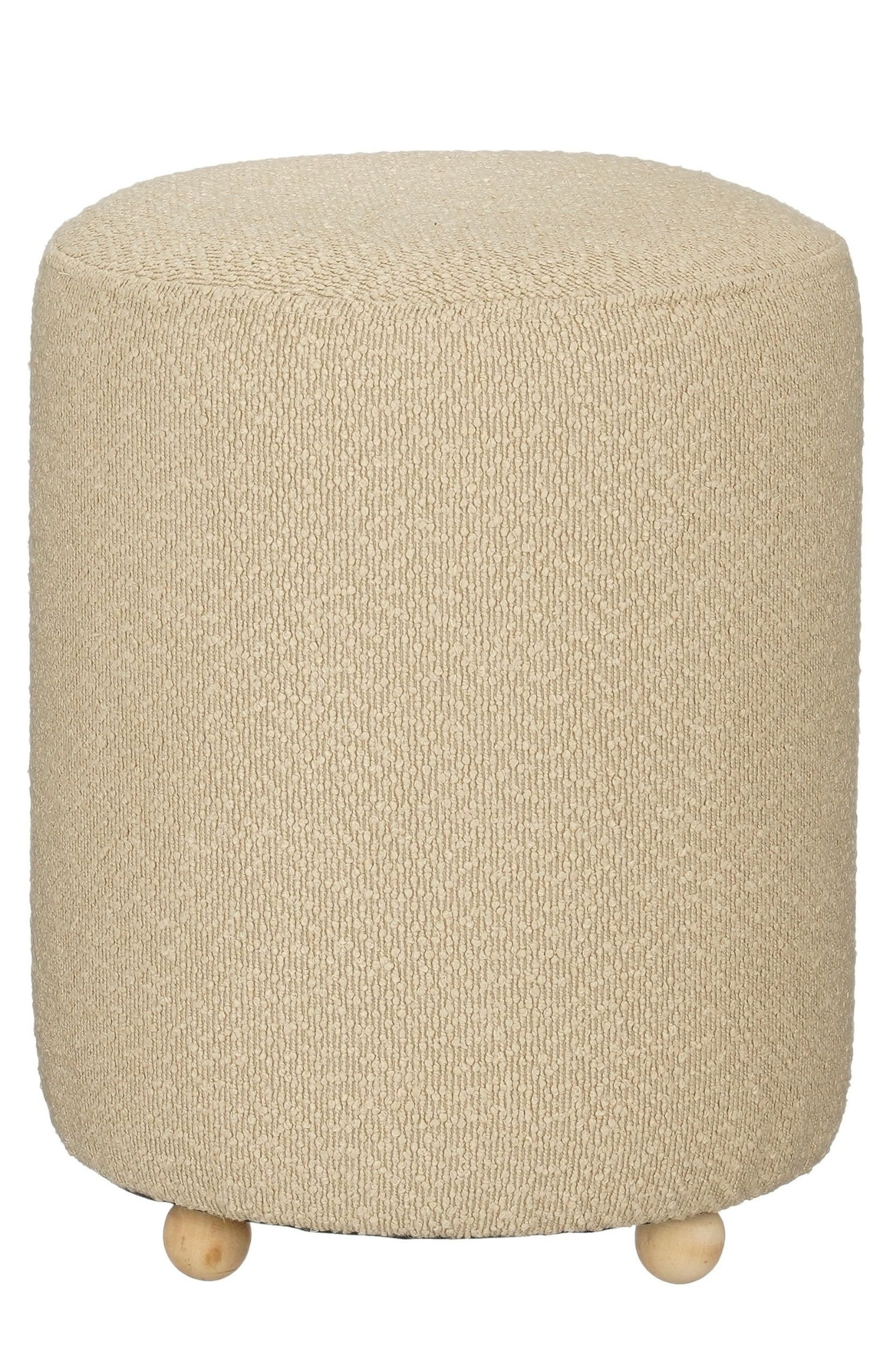 Agrandir l'image: Un pouf cylindrique se tient bien droit, mettant en valeur son revêtement bouclé beige texturé et son dessus arrondi. Le pouf repose sur de petits pieds sphériques en bois visibles à la base.