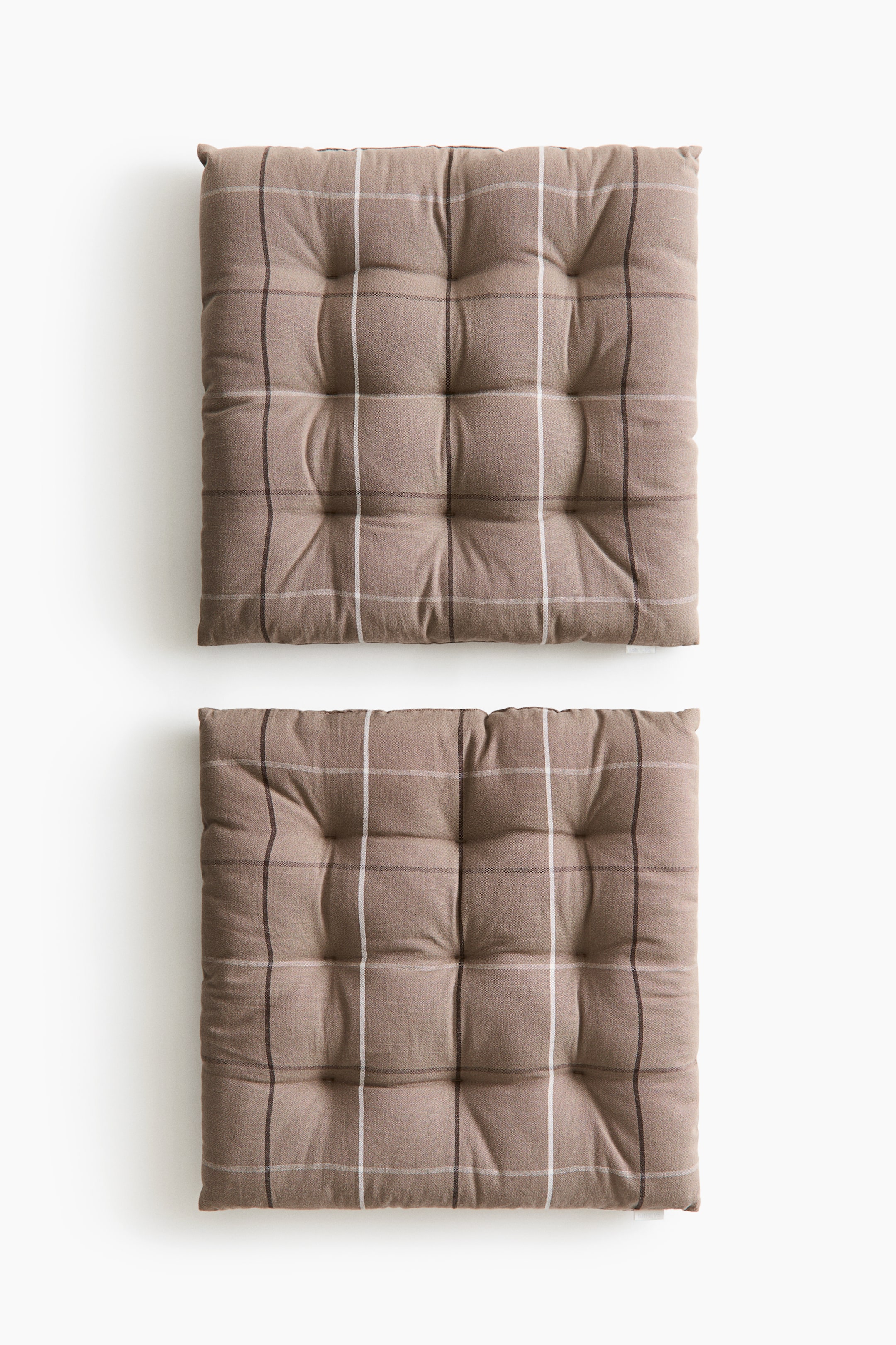 Voir une image plus grande: Deux coussins de siège carrés présentent un tissu beige avec un motif à carreaux de lignes blanches et brun foncé. Chaque coussin est capitonné, formant neuf sections carrées individuelles.