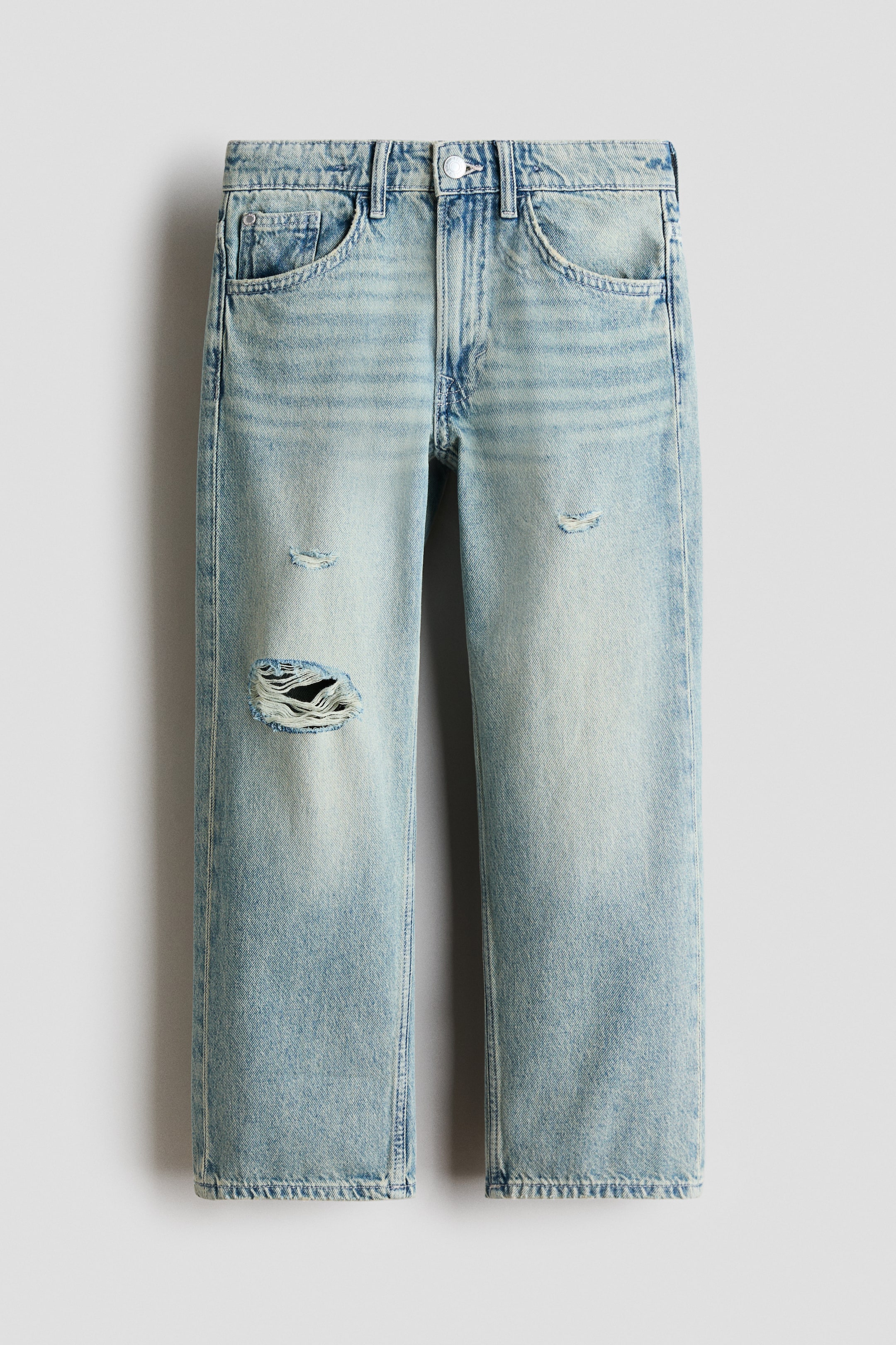 View larger image: FRONT view of loose-fit, 5-pocket jeans in washed light blue cotton denim. They feature a zip fly with a button closure, straight legs, and distressed details, including a large rip on the left thigh and smaller abrasions on both thighs.