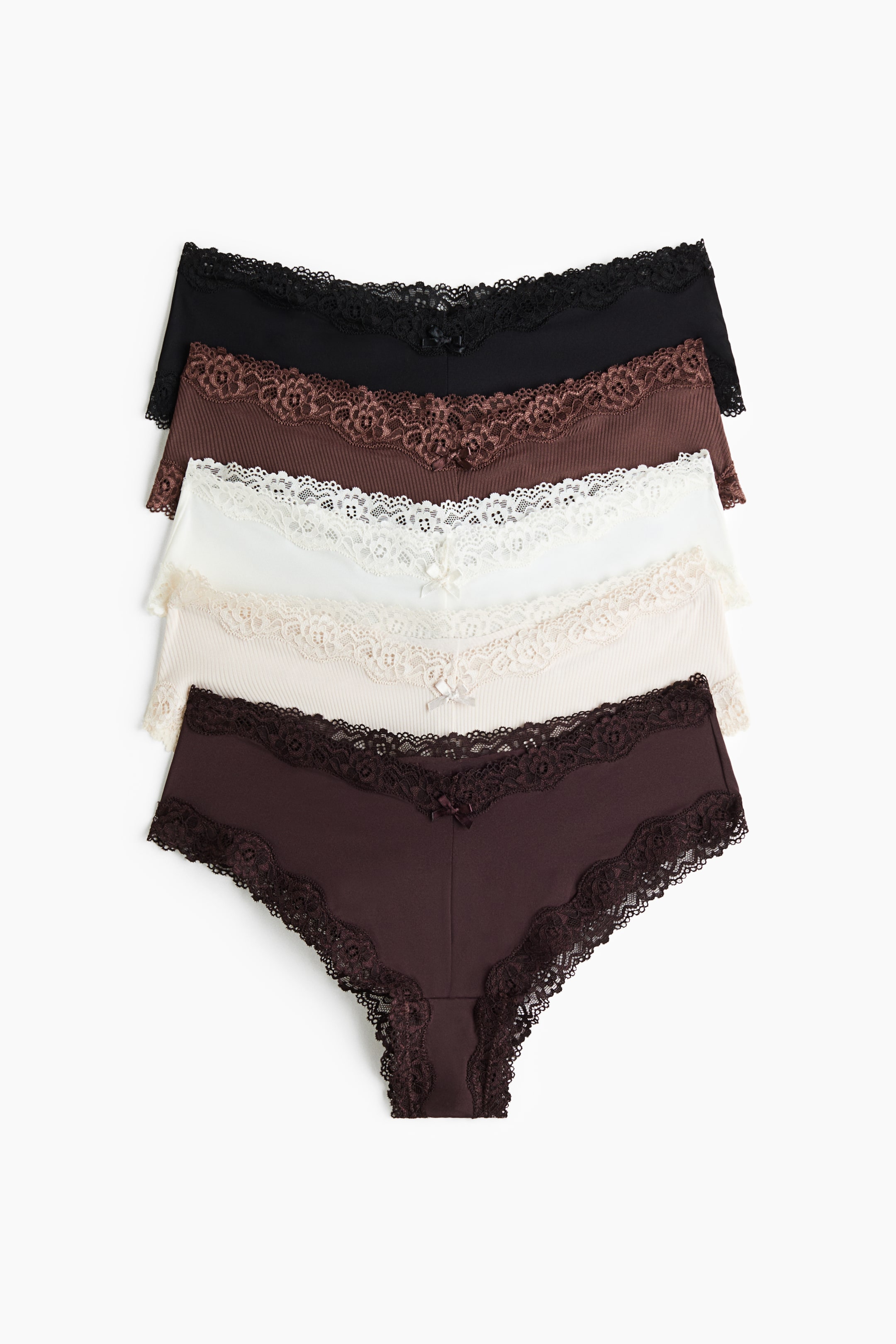 Visualizza l'immagine ingrandita: Cinque paia di slip in nero, marrone, bianco, crema e prugna scuro sono disposti in una pila sovrapposta vista frontalmente. Ogni paio presenta una vita bassa a V con rifiniture in pizzo smerlato coordinate lungo la fascia in vita e le aperture delle gambe, impreziosita da un piccolo fiocco decorativo al centro.