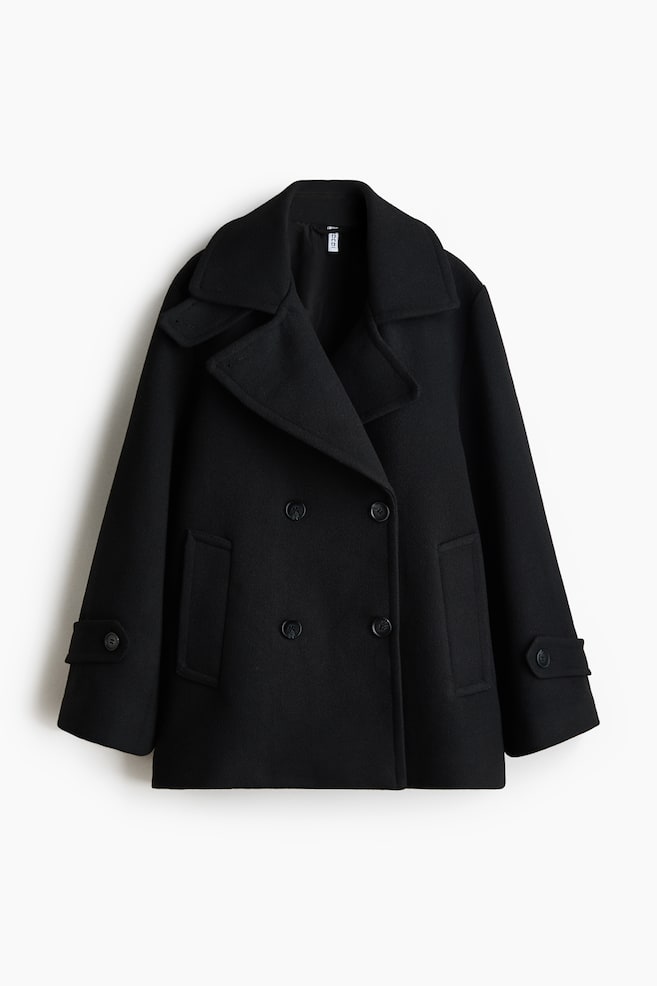 Este prezentat un palton peacoat negru, cu Ã®nchidere dublu-rÃ¢nd, vÄzut din faÈÄ, cu revere largi crestate Èi Ã®nchidere frontalÄ cu patru nasturi. Paltonul are buzunare drepte verticale tip welt pe laterale Èi mÃ¢neci largi, cu bride decorative cu nasturi la manÈete. - 1
