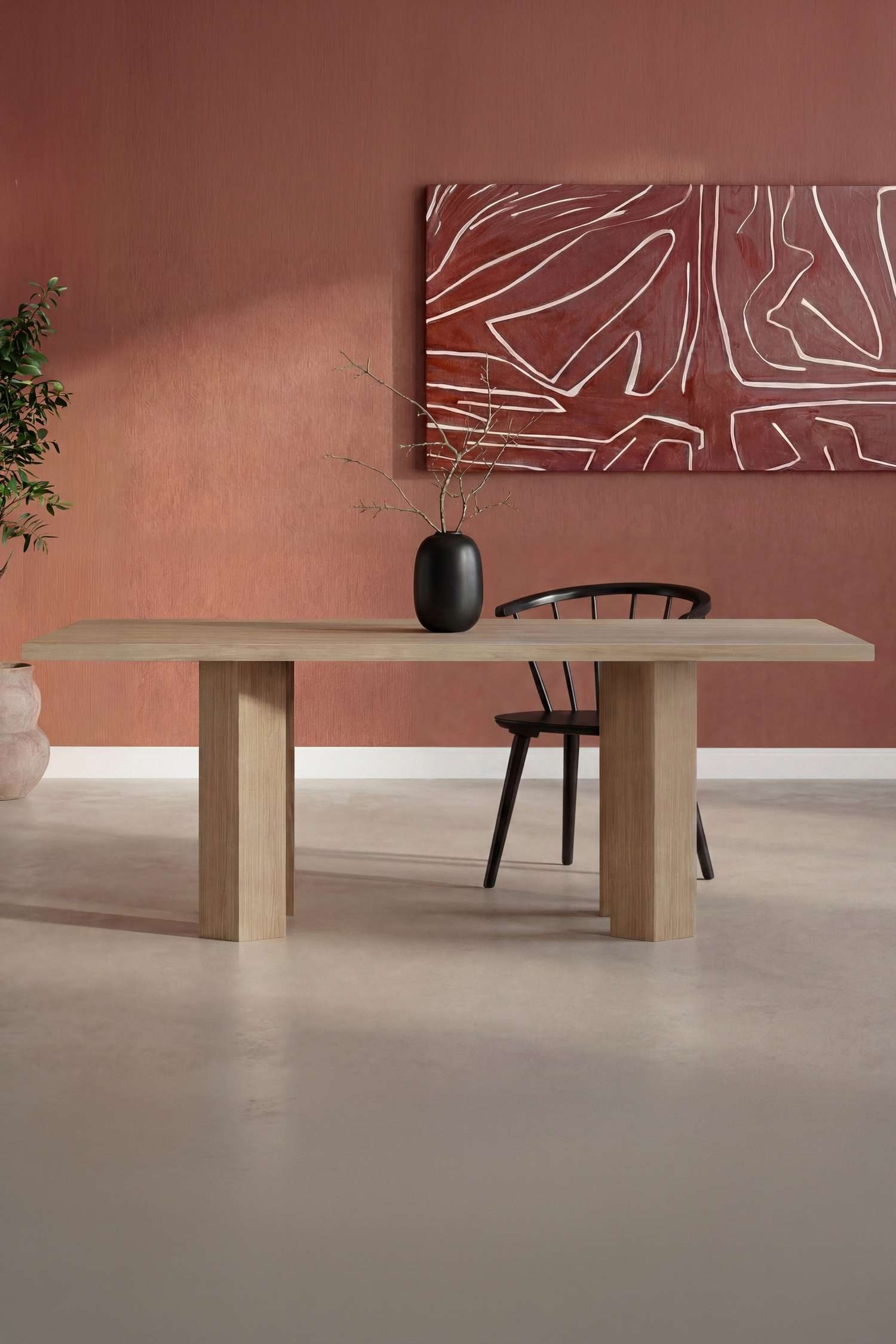 Une table en bois clair est orientée de face, présentant un plateau rectangulaire épais avec un grain visible. Elle est soutenue par deux pieds piédestaux rectangulaires substantiels, chacun présentant un angle subtil vers l'intérieur à sa base.