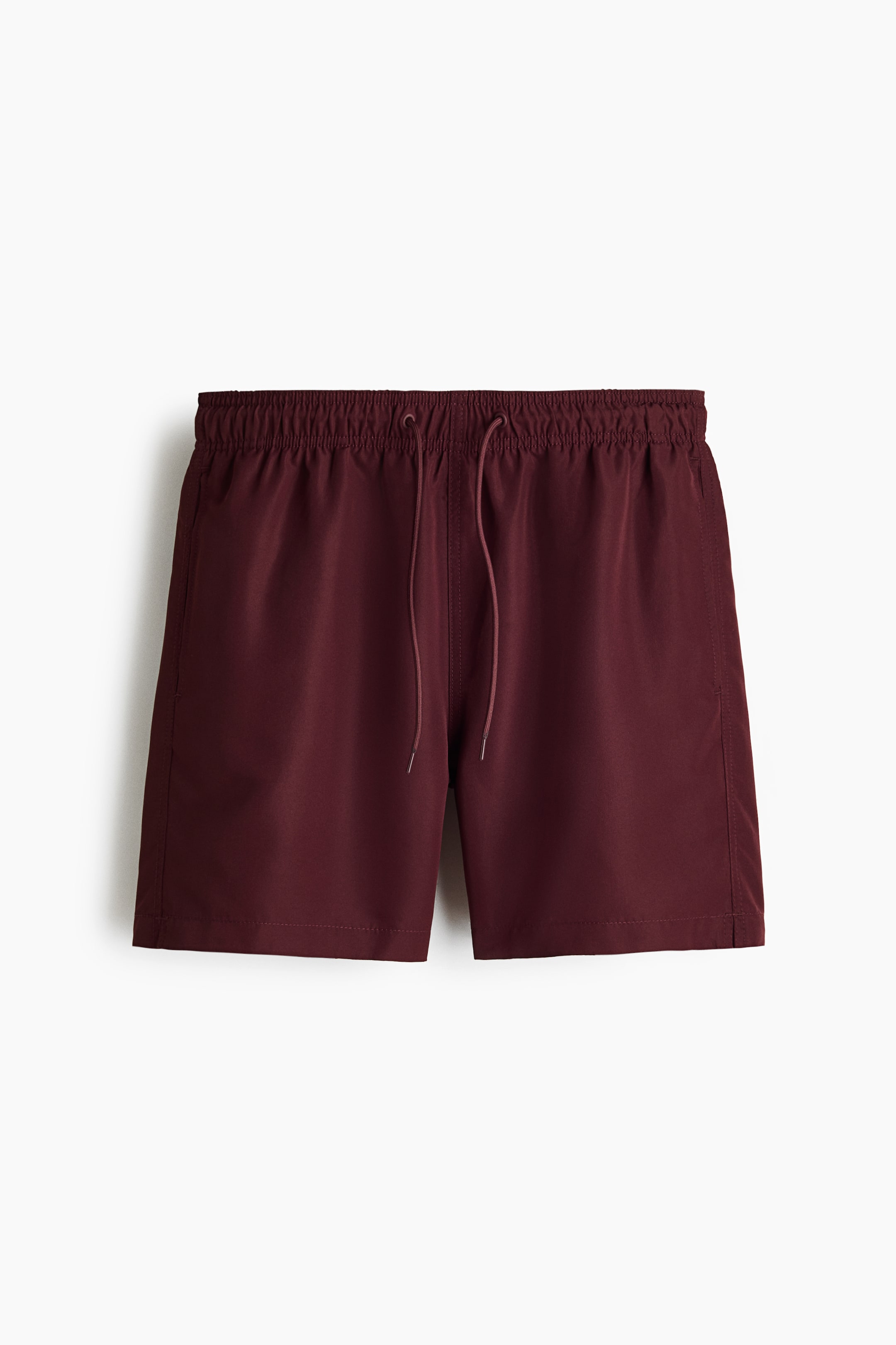Voir une image plus grande: Les shorts de bain sont présentés de face, mettant en valeur un tissu tissé rouge foncé. Ils sont conçus avec une taille élastiquée et un cordon de serrage, ainsi que des poches latérales discrètes et de petites fentes sur les côtés.