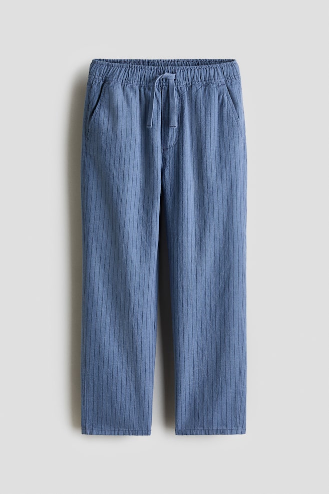 The blue pants are shown from the front, featuring narrow vertical stripes, an elasticated drawstring waistband, and two side pockets. - 1