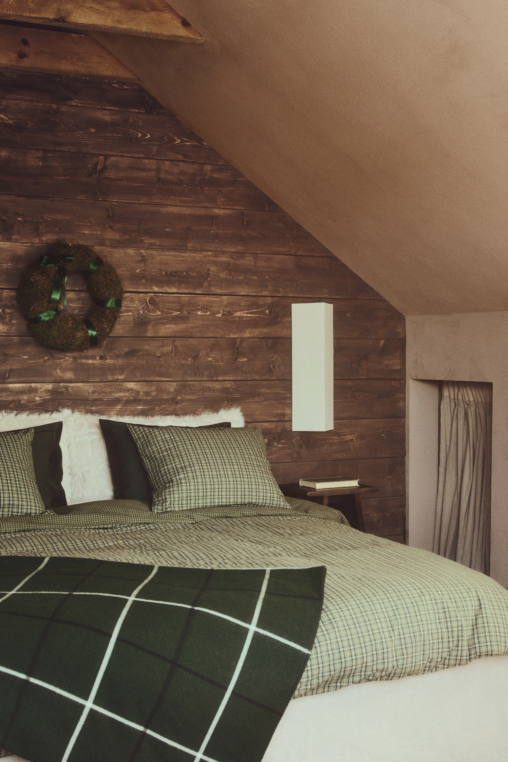 View larger image: A cotton flannel duvet cover set featuring a green and white mini-check pattern is covering a bed, showing a duvet cover and two matching pillowcases. A dark green blanket with a large white windowpane check pattern is lying across the foot of the bed.