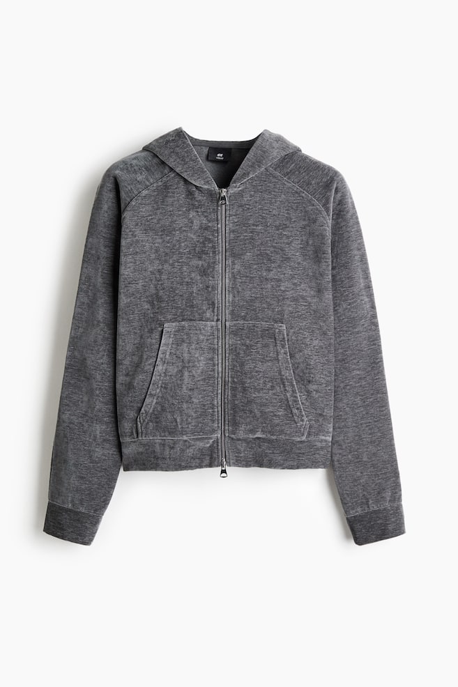 A dark grey velour hooded jacket is shown from the front, featuring a two-way front zipper, a lined hood, and split front pockets. The relaxed-fit jacket displays dropped shoulders, long sleeves with ribbed cuffs, and a ribbed hem. - 1