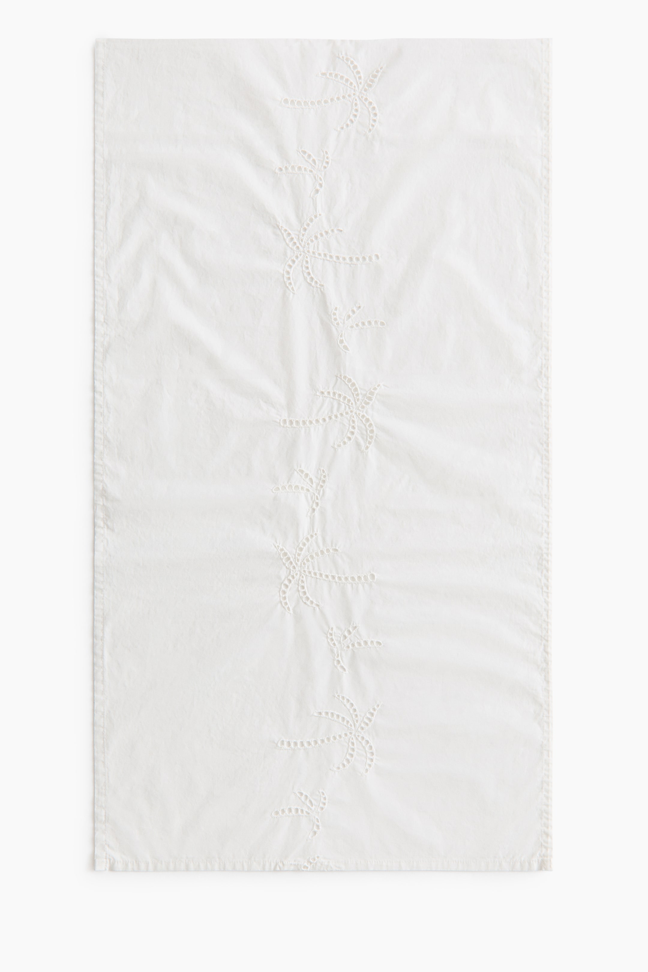 View larger image: A white rectangular fabric item is lying flat, showcasing a central column of embroidered stylised palm tree designs. The embroidery is detailed with cutwork and small dot accents.
