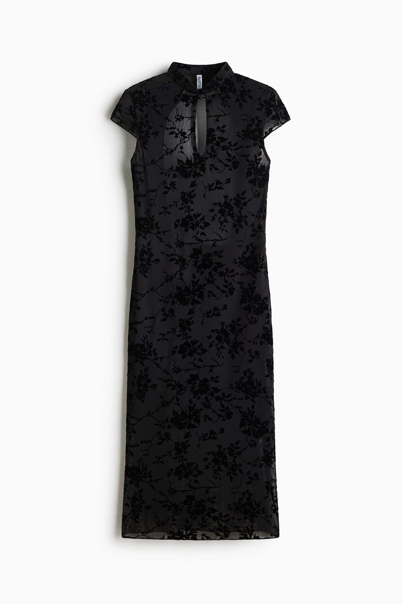 Une robe midi noire vue de face, mettant en valeur un tissu en maille transparente avec un motif floral en velours floqué sur toute la surface. La robe présente un col montant, une ouverture en goutte d’eau sur le devant, de petites manches à capuchon et une silhouette droite.