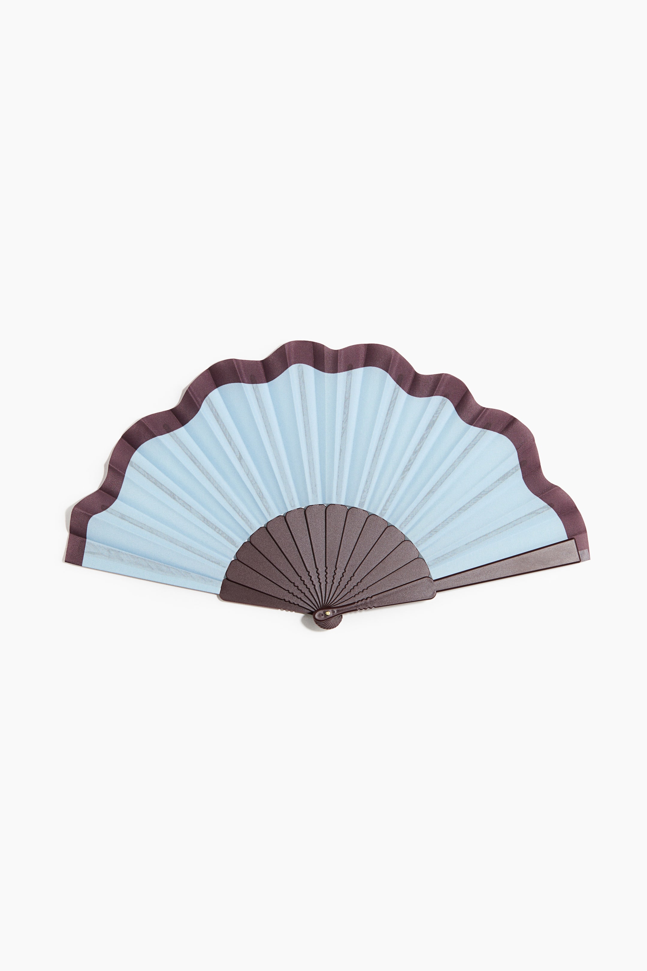 View larger image: A folding fan in plastic and fabric with a metal stud at the base presents its fully open, light-blue pleated fabric seen from the front. The fabric features a wavy top edge, bordered by dark-brown material that also forms the fan's frame and ribs, with a central metal stud securing the pivot point.
