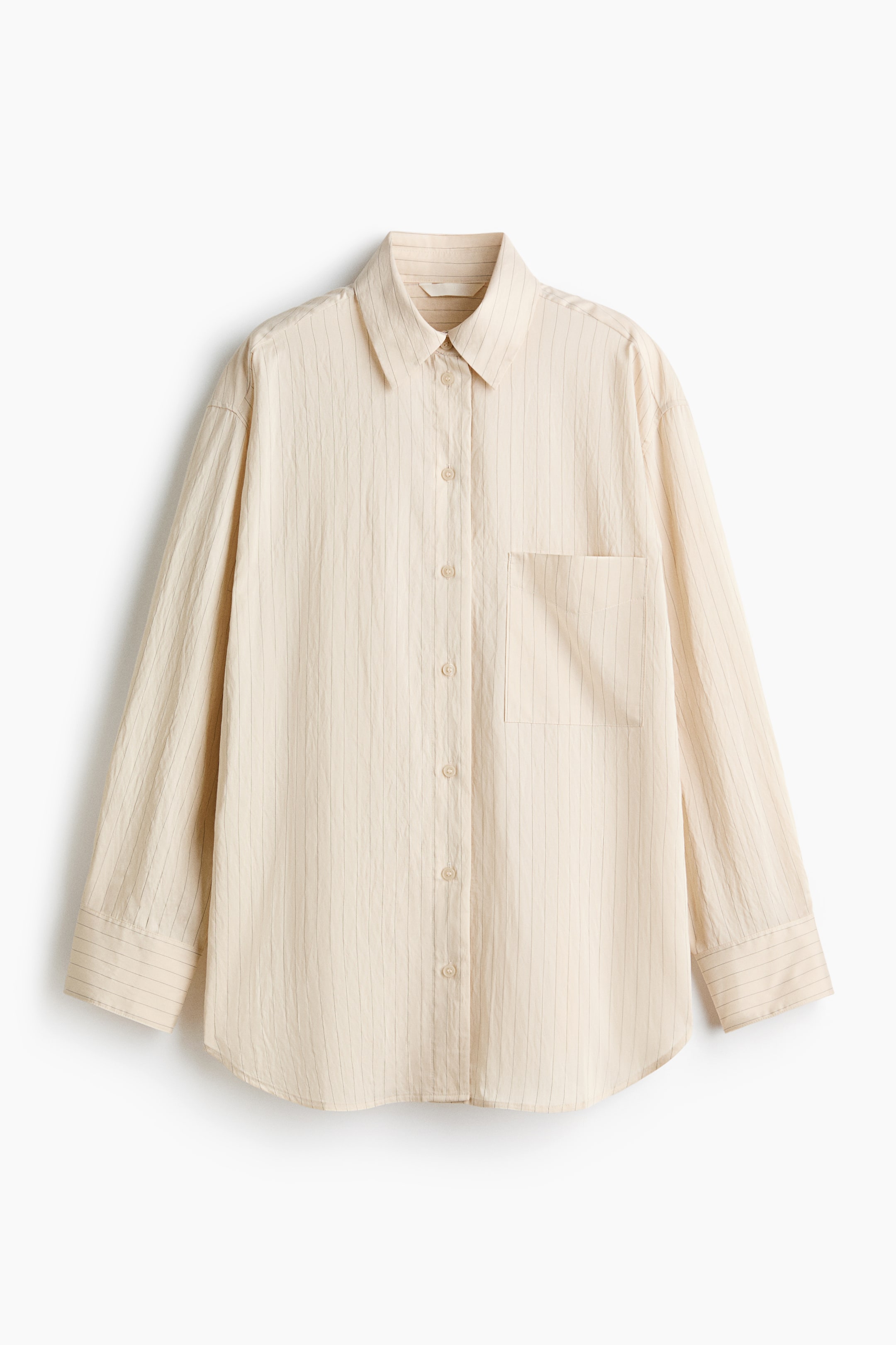 View larger image: A light beige shirt is shown from the front, featuring subtle vertical textured stripes across the fabric. It has a classic collar, a full button-through front with light-coloured buttons, a patch pocket on the left chest, long sleeves with buttoned cuffs, and a curved hemline.