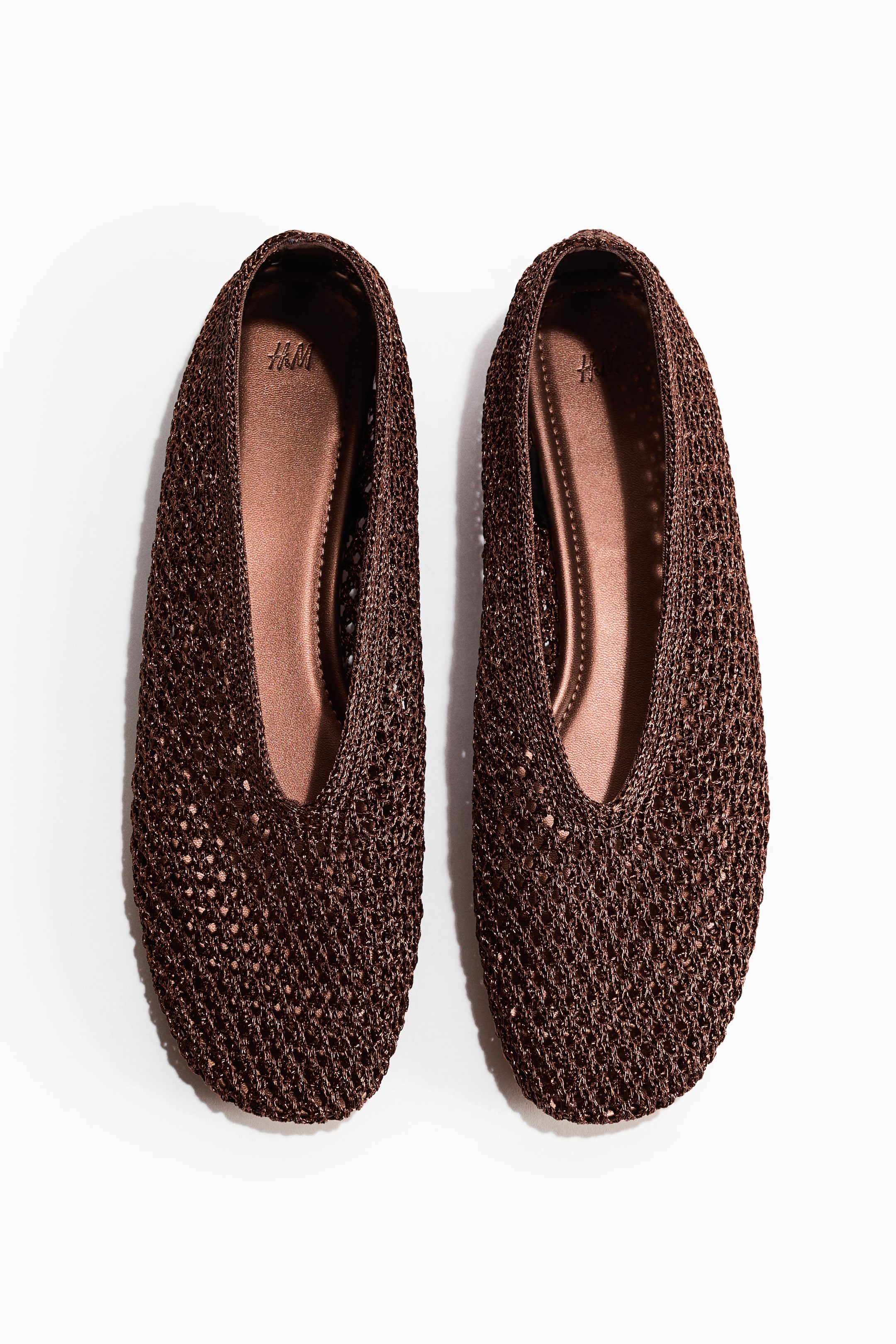 View larger image: Ballet flats showcase a dark brown braided plastic straw upper with rounded toes and brown insoles displaying an H&M logo.