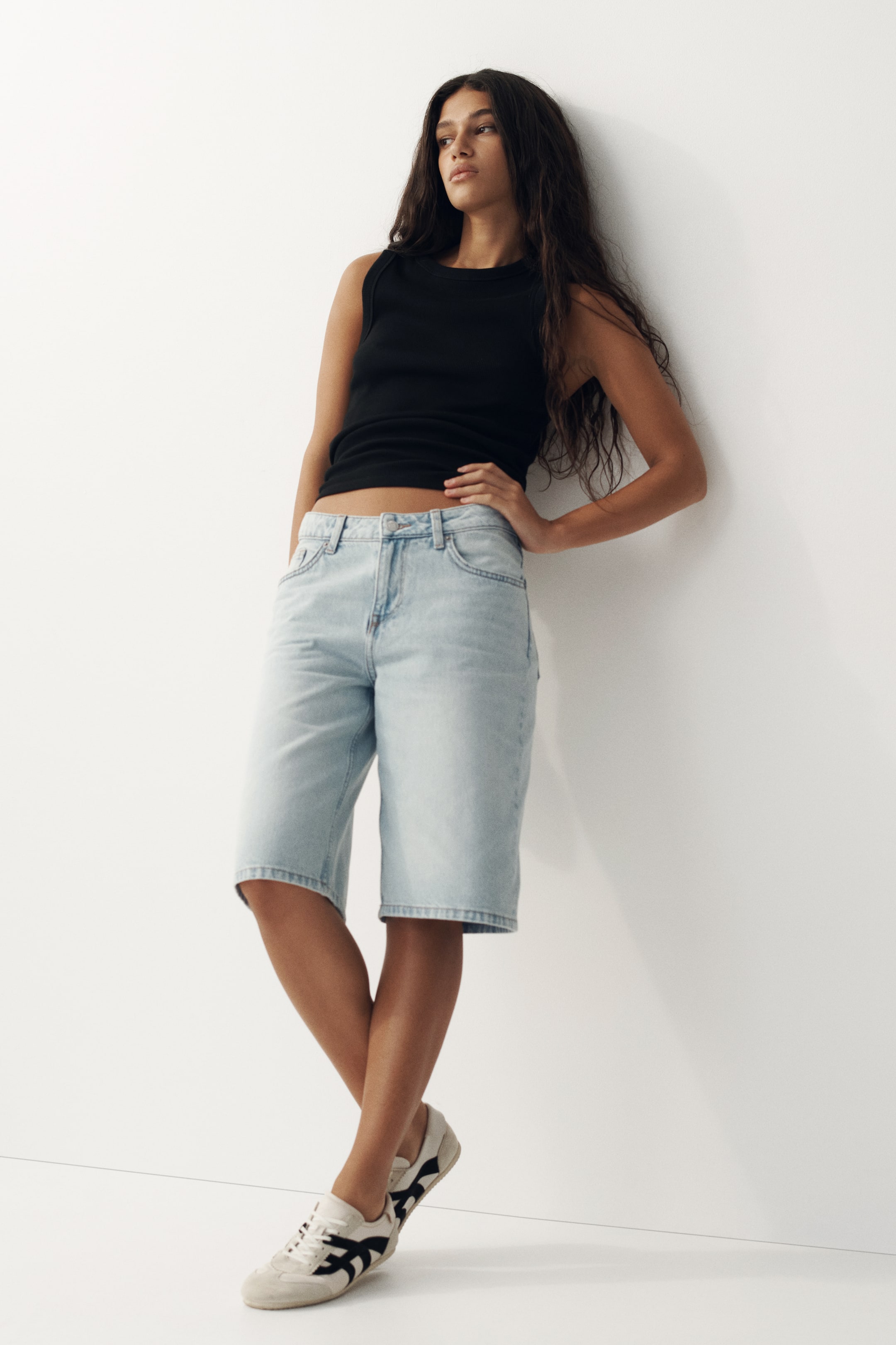 View larger image: 黑色羅紋針織背心，設有圓領和無袖設計，展現出貼身的輪廓，長度至腰部。