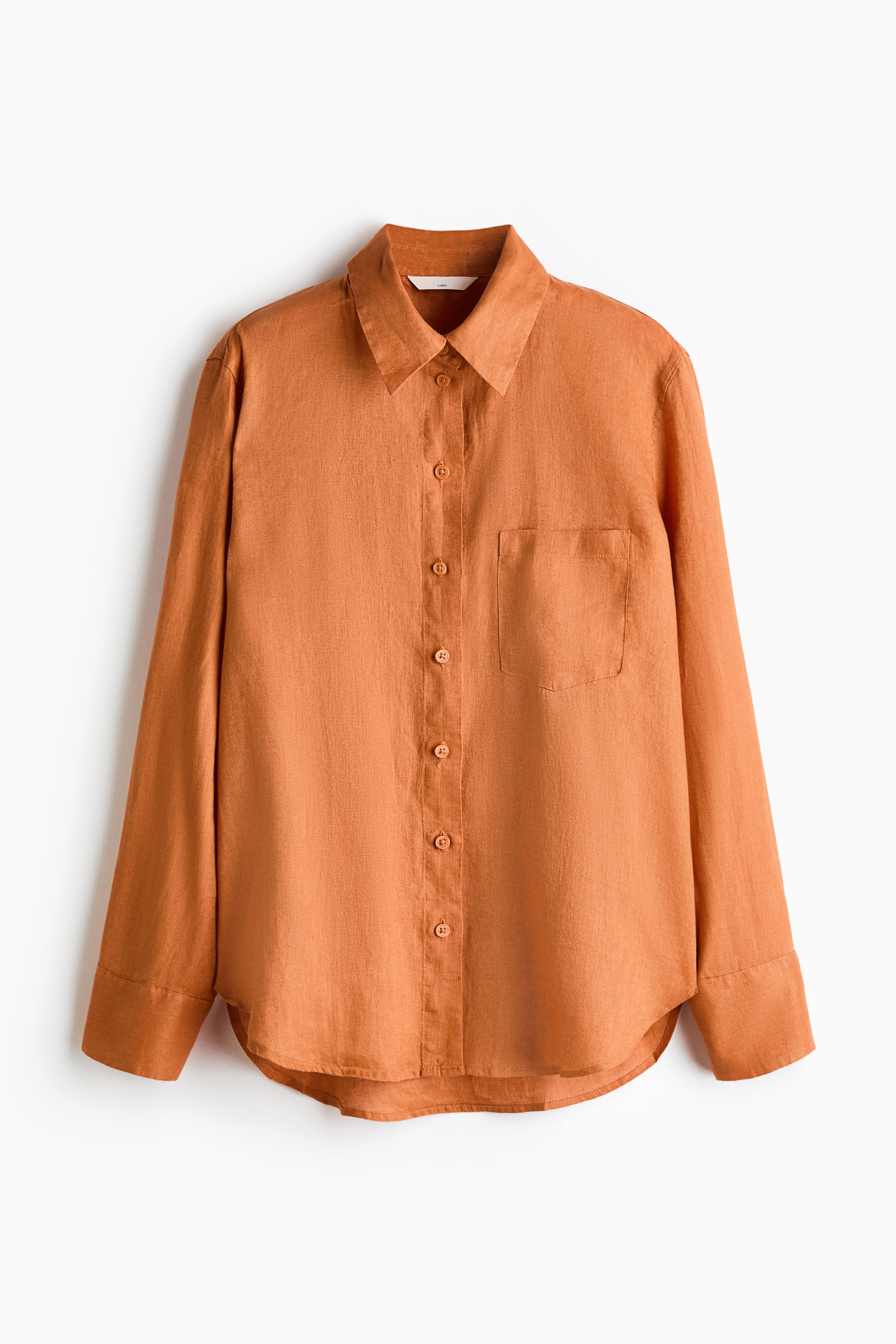 View larger image: This product showcases an orange linen shirt viewed from the front, highlighting a collar and a button-down front. It features an open chest pocket, long sleeves with buttoned cuffs, and a straight-cut hem with curved side vents.