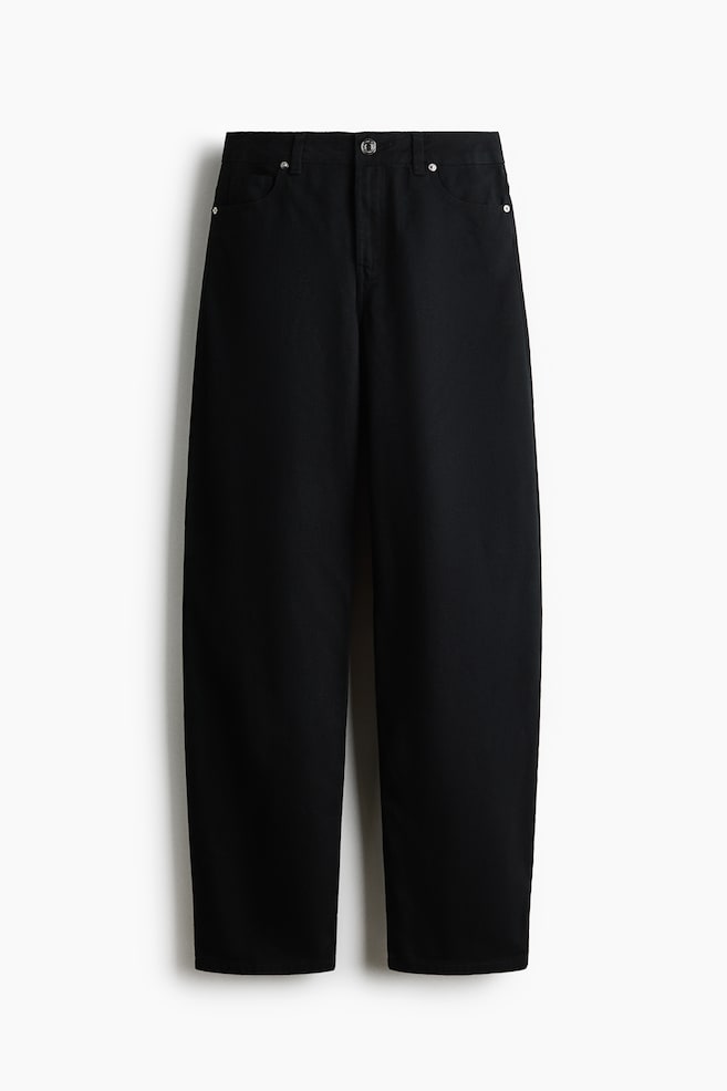 These black wide-leg jeans, shown from the front, feature a classic five-pocket design with silver-tone metal rivets and a central button closure. The trousers display a relaxed, straight-leg silhouette and include belt loops along the waistband. - 1