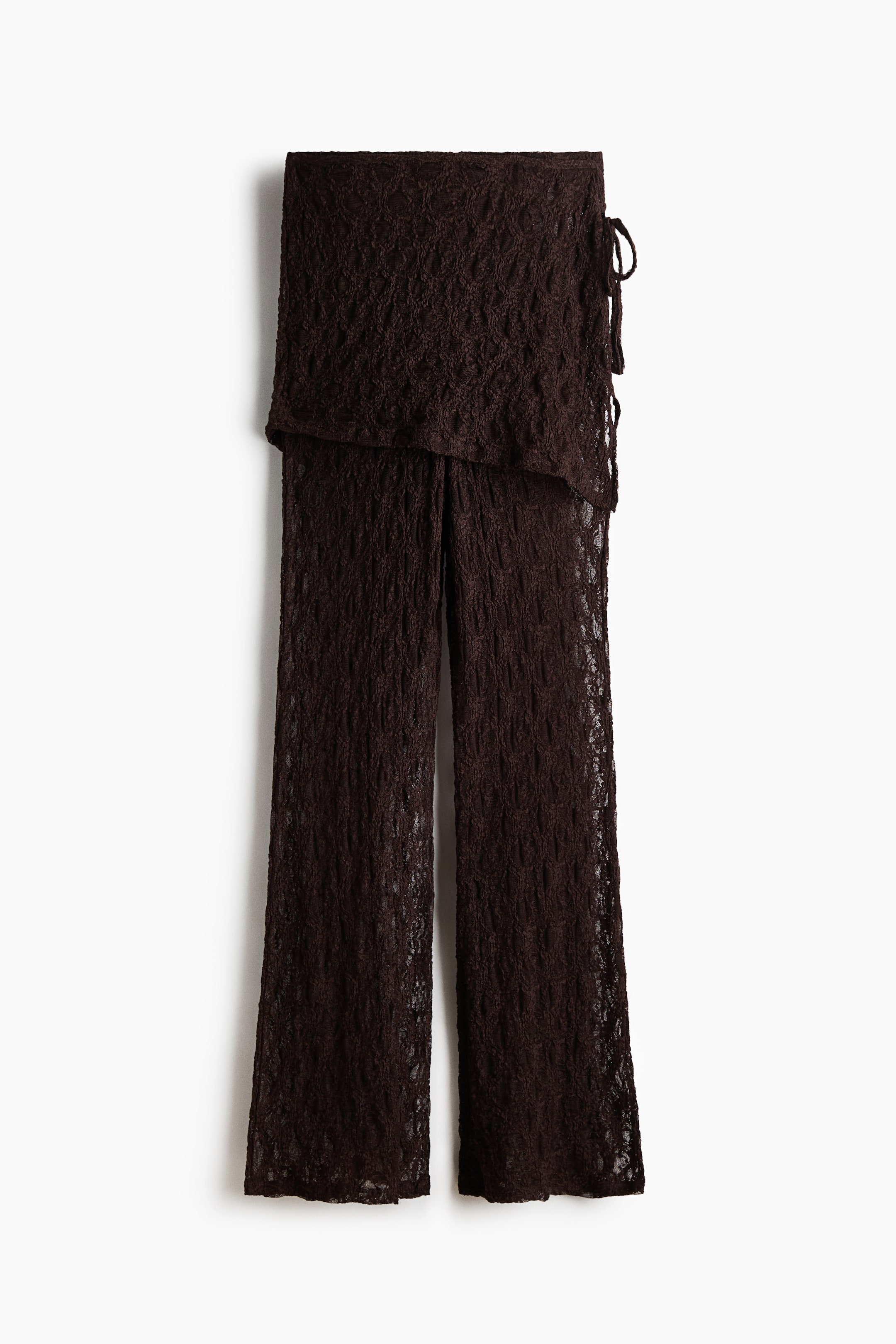 View larger image: The dark brown, textured trousers feature a sheer, open-knit fabric and a wide, wrap-style overlay that ties on the right side. From the front, the trousers present a straight-leg silhouette.