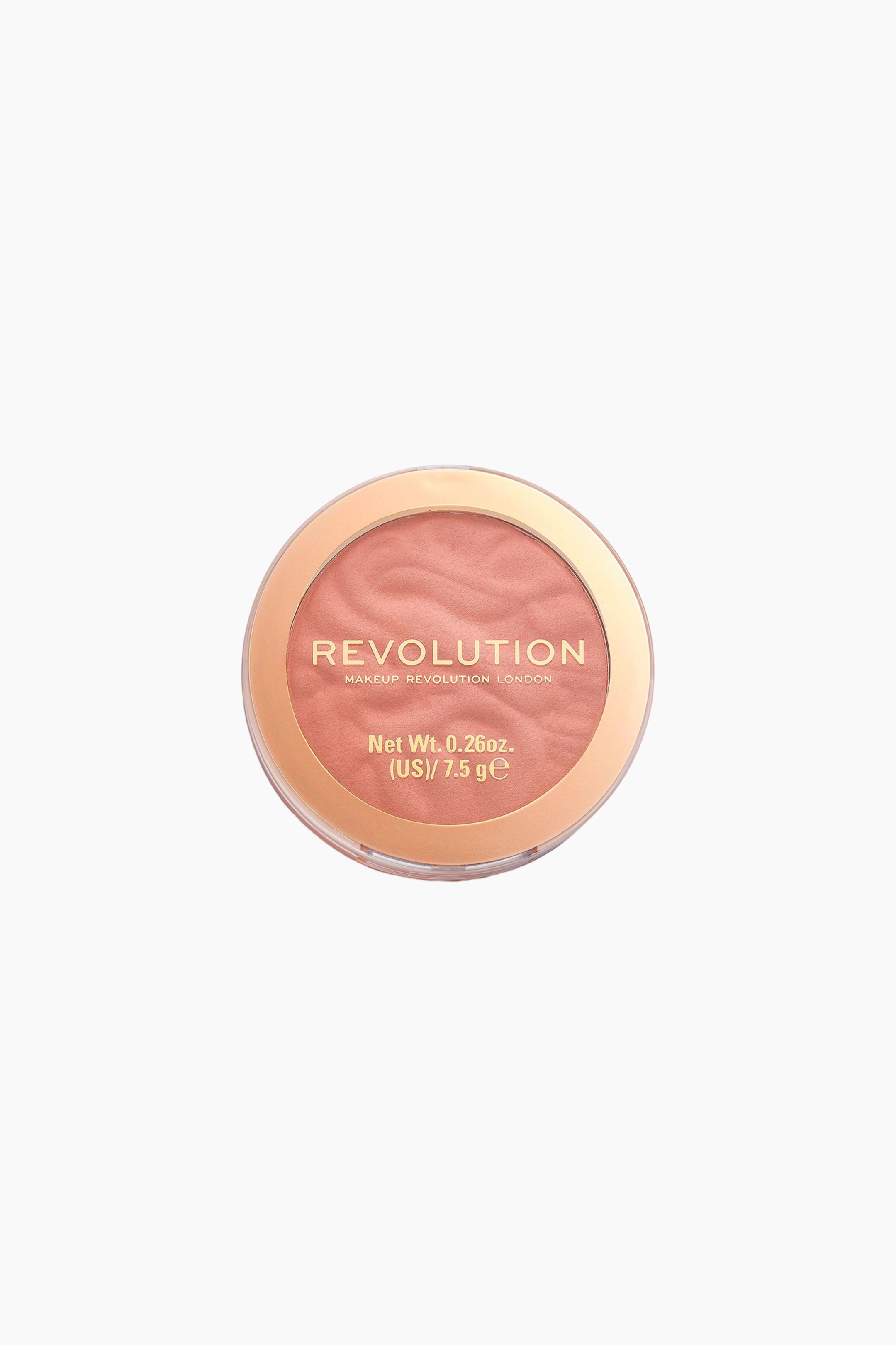Visa större bild: Ett runt kompaktrouge visar ett persikorosa puder med vågig, texturerad yta genom det genomskinliga locket. Locket har en metallisk roséguldfärgad cirkulär kant och guldbokstäver med texten "REVOLUTION MAKEUP REVOLUTION LONDON" samt information om produktens vikt.