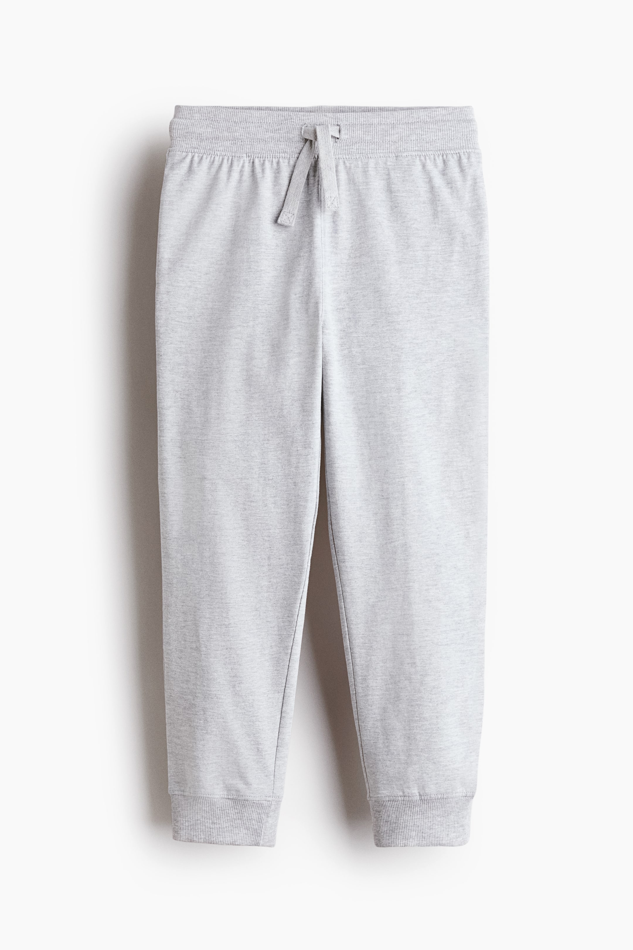 View larger image: "Light grey sweatpants showcase a front view, featuring a ribbed elastic waistband with a drawstring tied in a bow, and ribbed ankle cuffs."