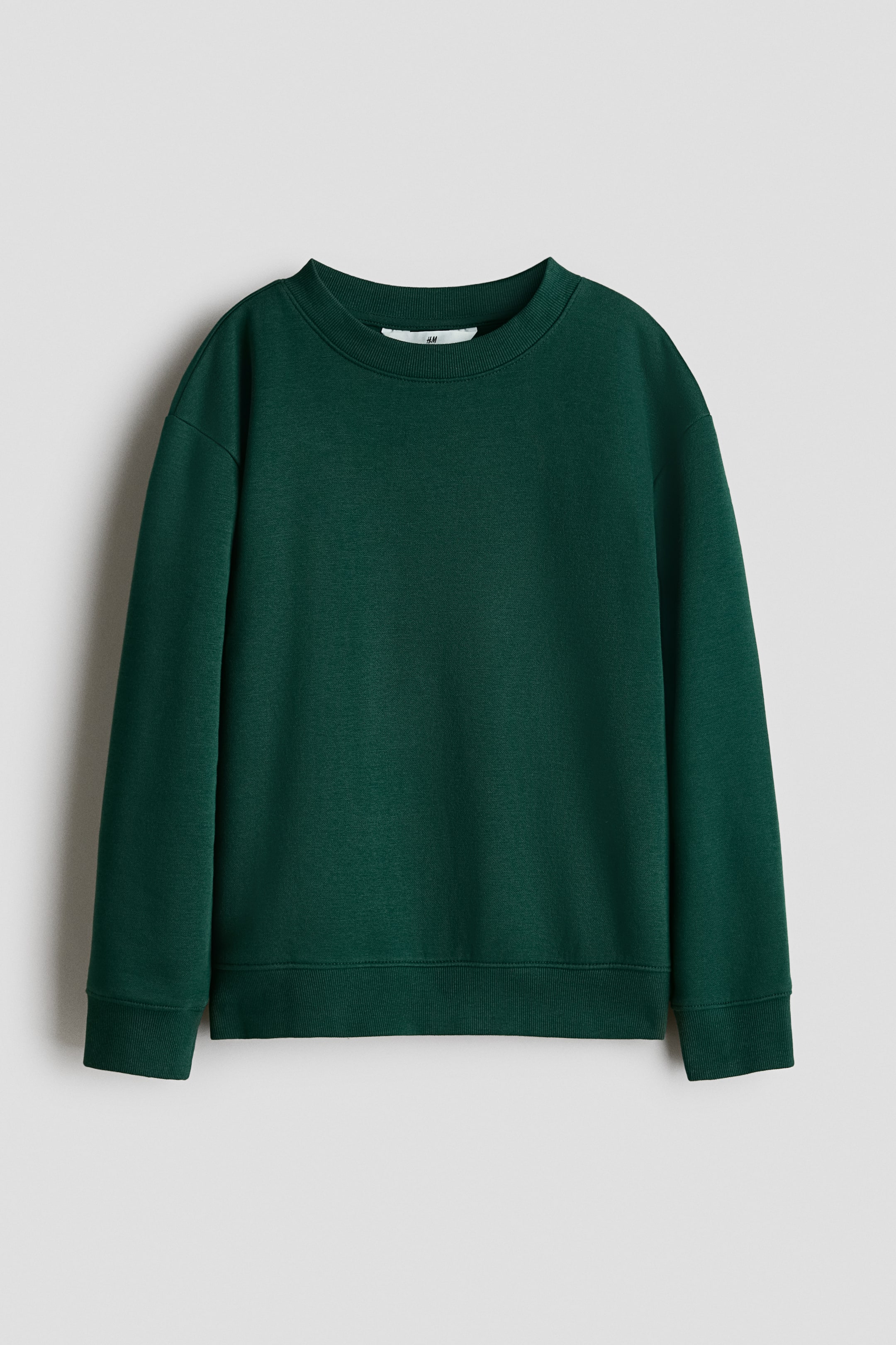 View larger image: A dark green sweatshirt is shown front-facing, crafted from a smooth fabric. It features a round, rib-trimmed neckline, dropped shoulders, and long sleeves. Ribbing is also visible at the cuffs and hem.