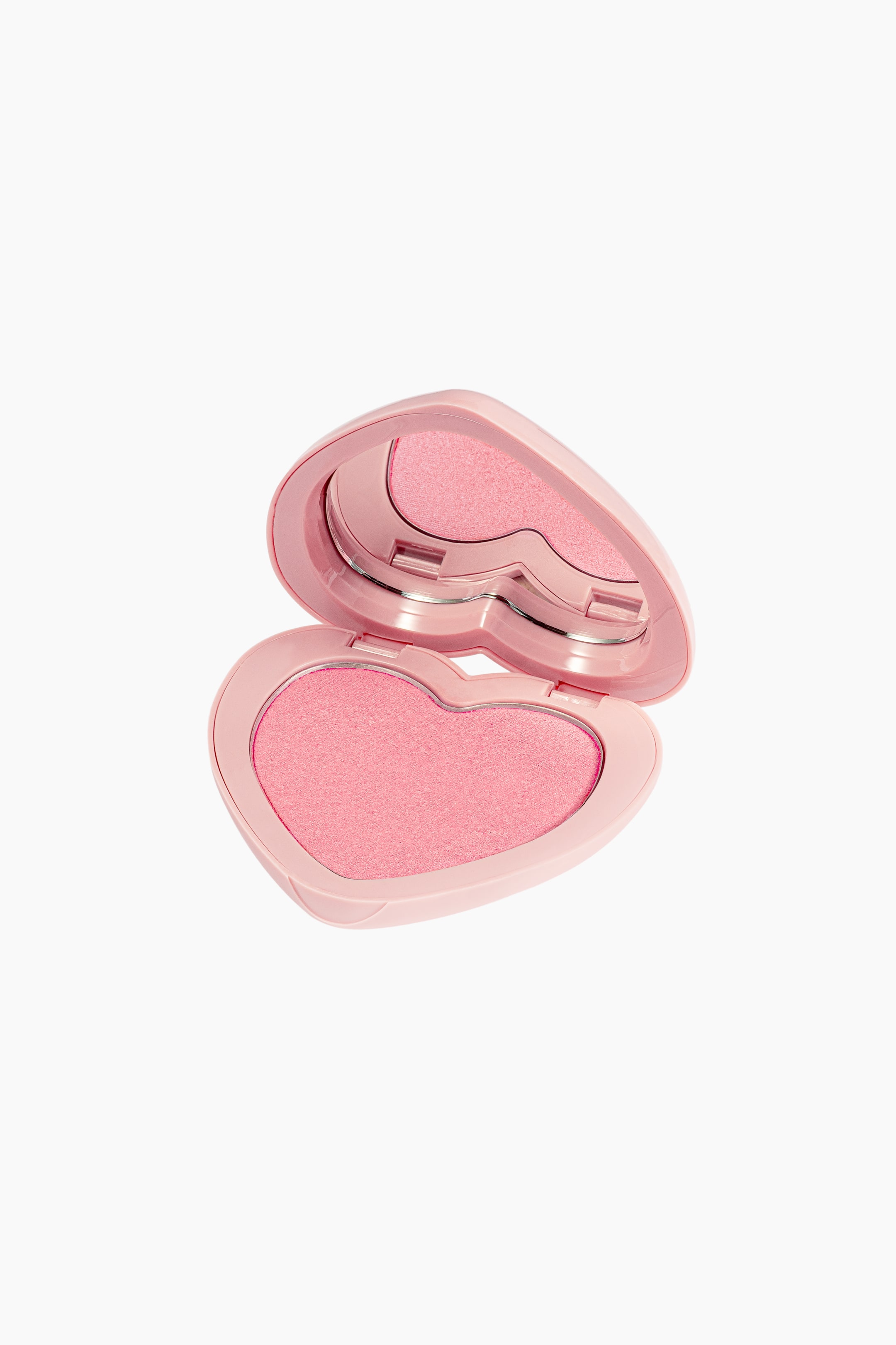 Visa större bild: En ljusrosa, hjärtformad sminkkompakt är öppen i en vinkel och avslöjar skimrande rosa puder och en hjärtformad spegel i locket.