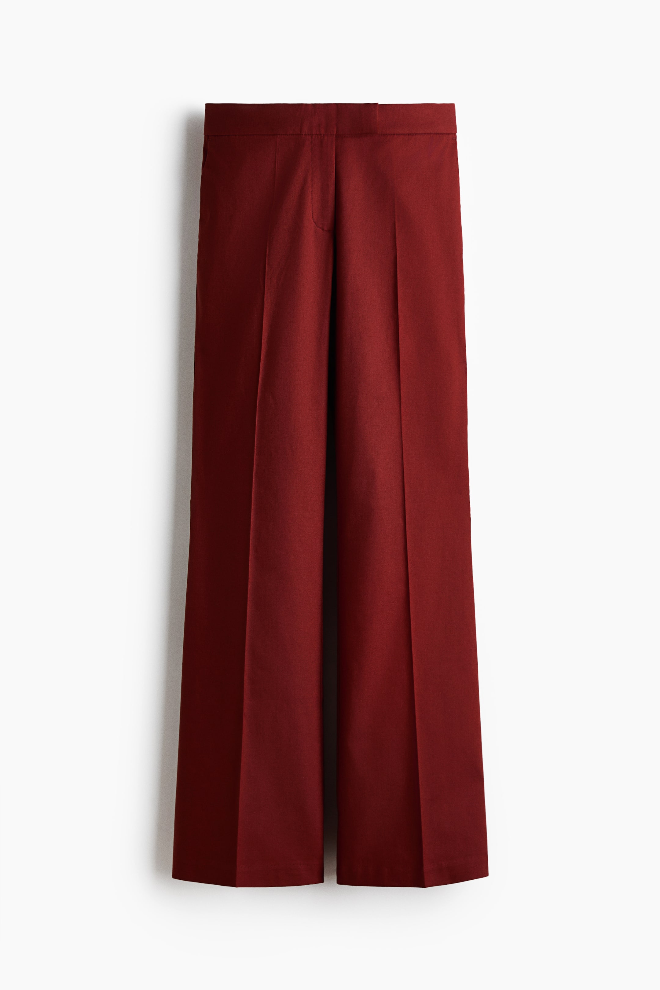 View larger image: The deep red wide-leg trousers are showcased in a front view, highlighting a flat waistband and pronounced creases extending down the center of each leg.