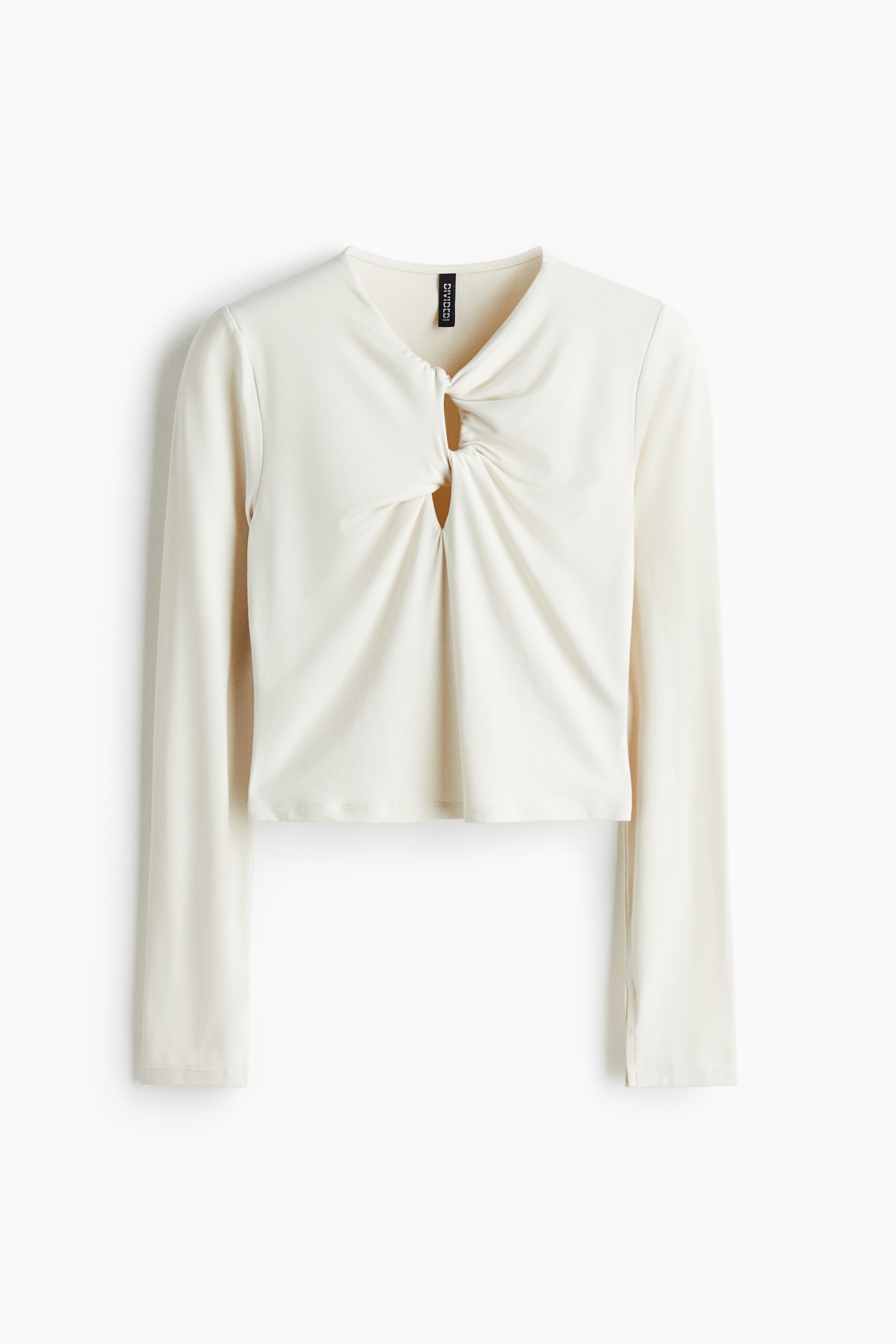 View larger image: A cream-colored, long-sleeve top is being displayed from the front, featuring a twisted knot detail at the center chest that is creating a keyhole opening and gathering the fabric. The top's cropped hem is visible, and its long sleeves are finishing with small slits at the outer edges of the cuffs.