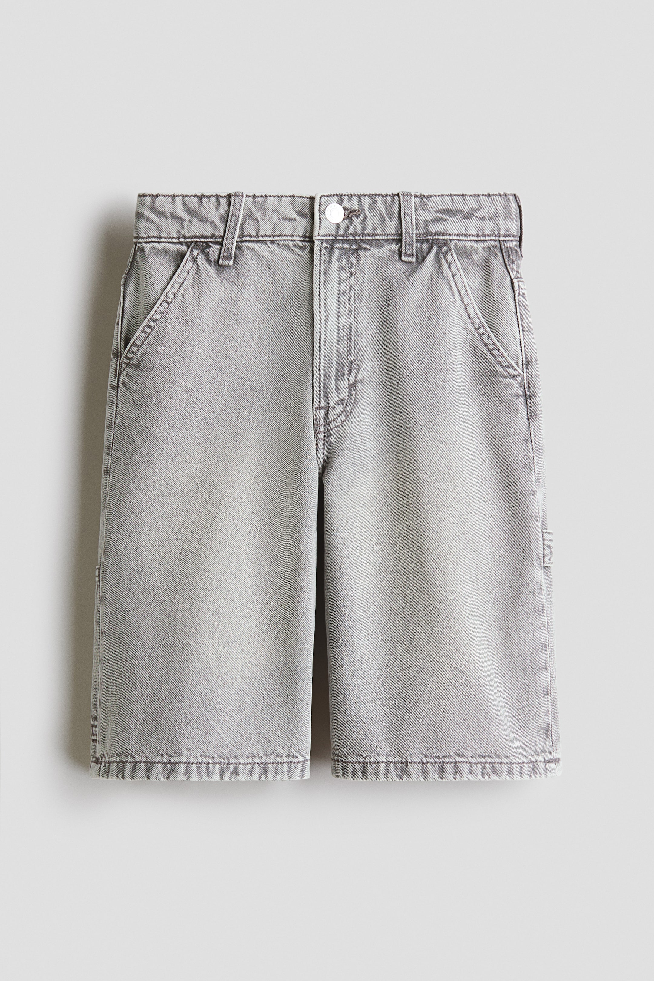 View larger image: Denim shorts showcase a light gray faded wash and are presented flat lay from the front. They feature a waistband with belt loops, a single button closure, a zipper fly, two front slash pockets, and a small tool loop on the right leg.