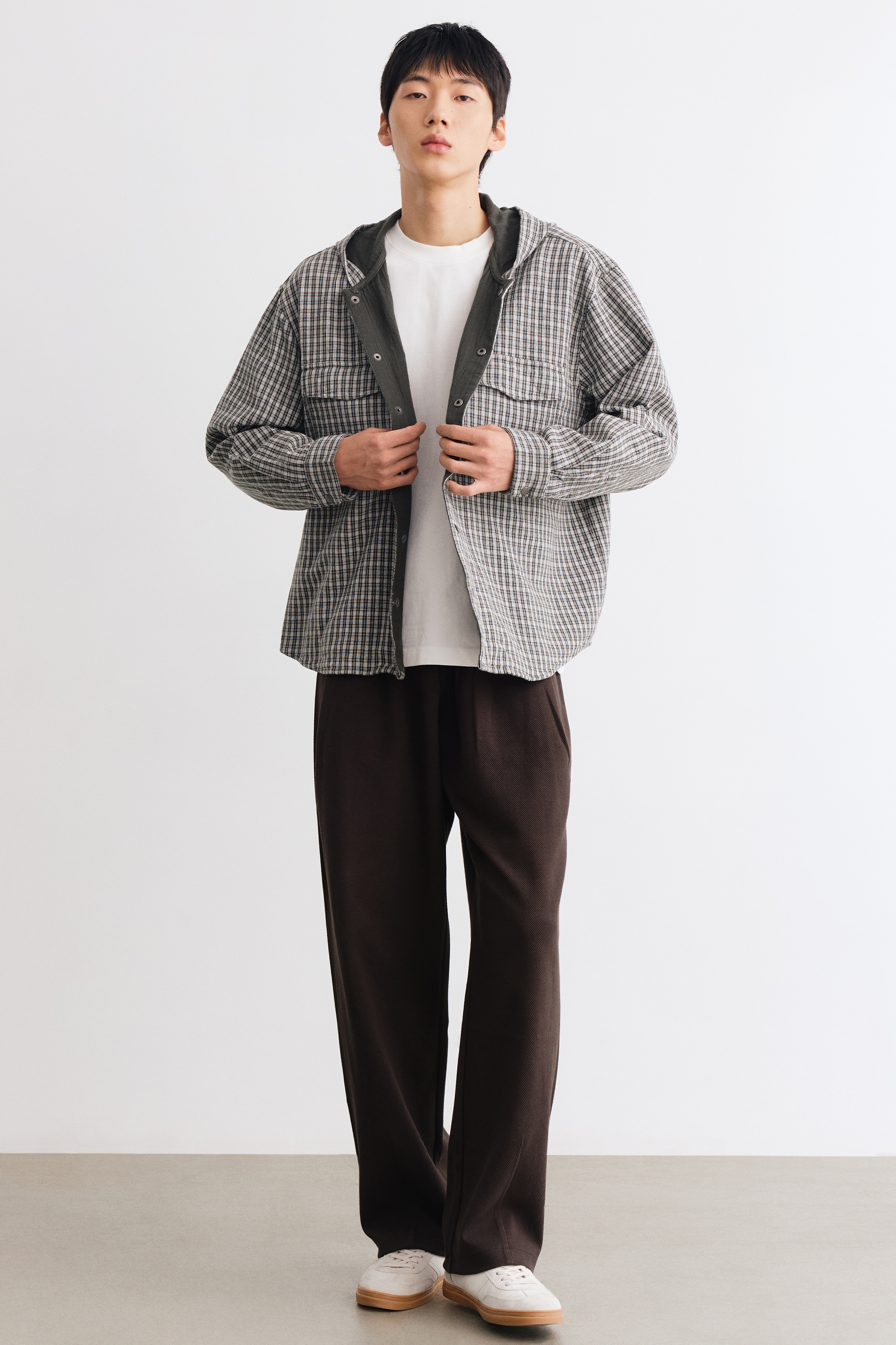 Chiáº¿c quáº§n dÃ i mÃ u nÃ¢u Äáº­m nÃ y, ÄÆ°á»£c chá»¥p tá»« phÃ­a trÆ°á»c, sá» há»¯u phom dÃ¡ng loose-fit vá»i cáº¡p chun nhÃºn vÃ  cÃ¡c ly xáº¿p á» máº·t trÆ°á»c. Quáº§n cÃ³ tÃºi chÃ©o bÃªn hÃ´ng cÃ¹ng á»ng rá»ng, thoáº£i mÃ¡i, vá»i cÃ¡c ÄÆ°á»ng ly dá»c tinh táº¿ á» gáº¥u quáº§n.
