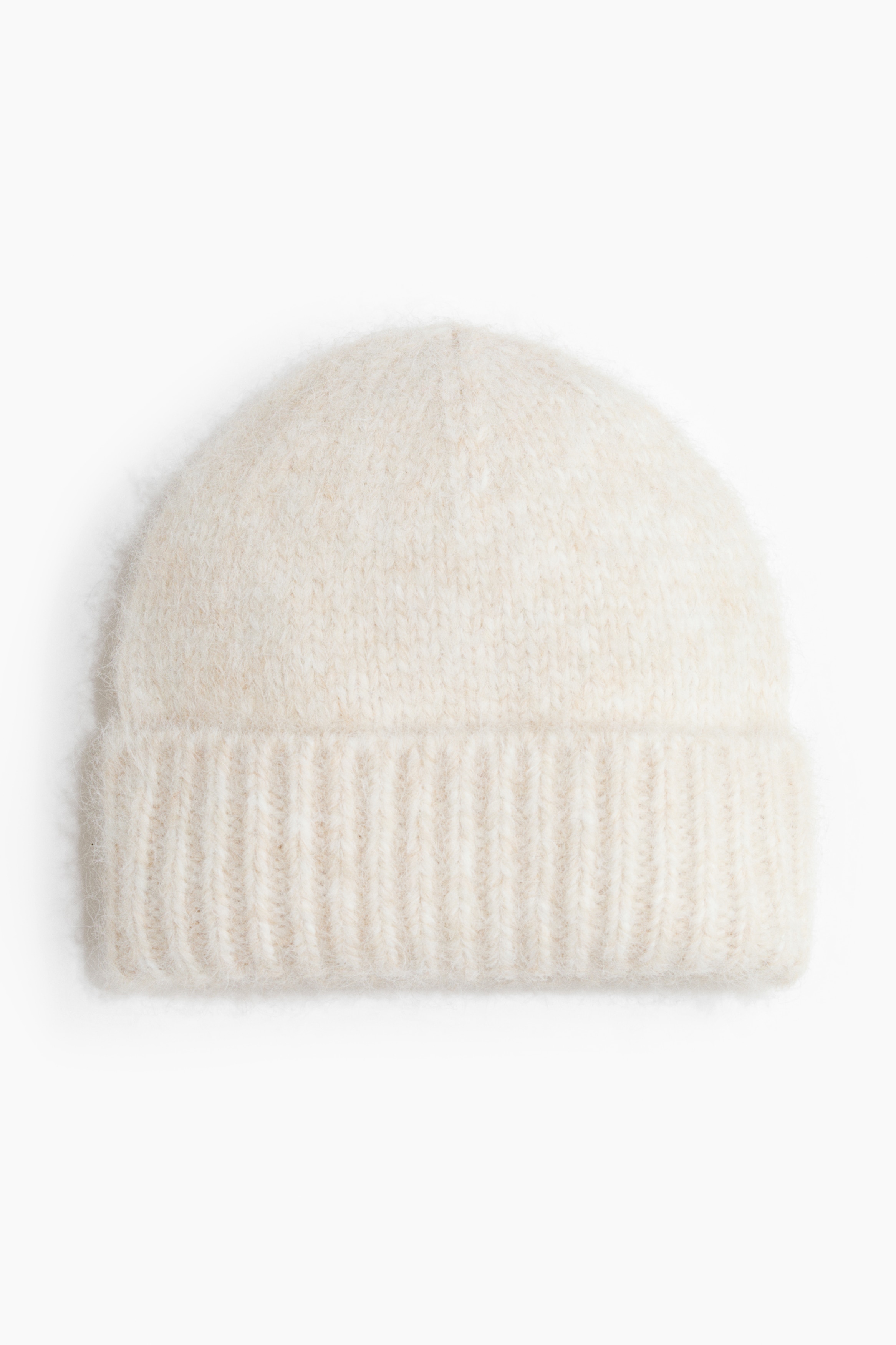 A cream-coloured beanie in a soft knit with a brushed finish and a ribbed turn-up hem is being worn by the model. The beanie is styled with a coordinating cream-coloured knit sweater layered over a white collared shirt.