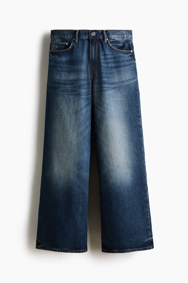 Dark blue wide-leg jeans are presenting a front view, featuring a high waist, two curved front pockets with a coin pocket, and faded distressed details on the thighs and pocket edges. - 1