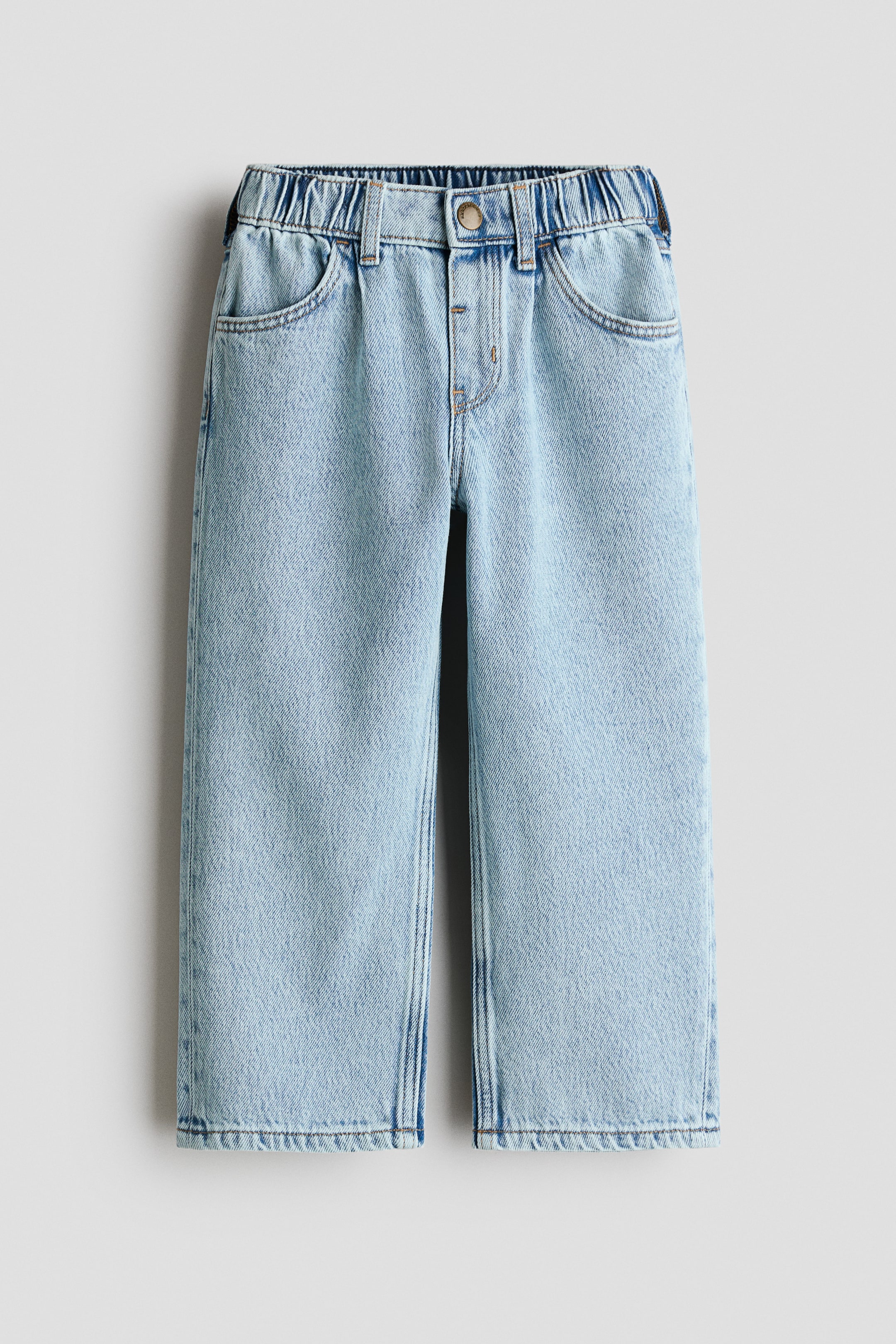 Größeres Bild anzeigen: H&M Adorables Jeans präsentieren sich frontseitig in einem hellblauen, gewaschenen Denim. Sie verfügen über einen elastischen Bund mit Gürtelschlaufen, einen Fake-Hosenschlitz mit Druckknopf, abgerundete Vordertaschen und Falten am oberen Teil, die in lange, weite Beine übergehen.