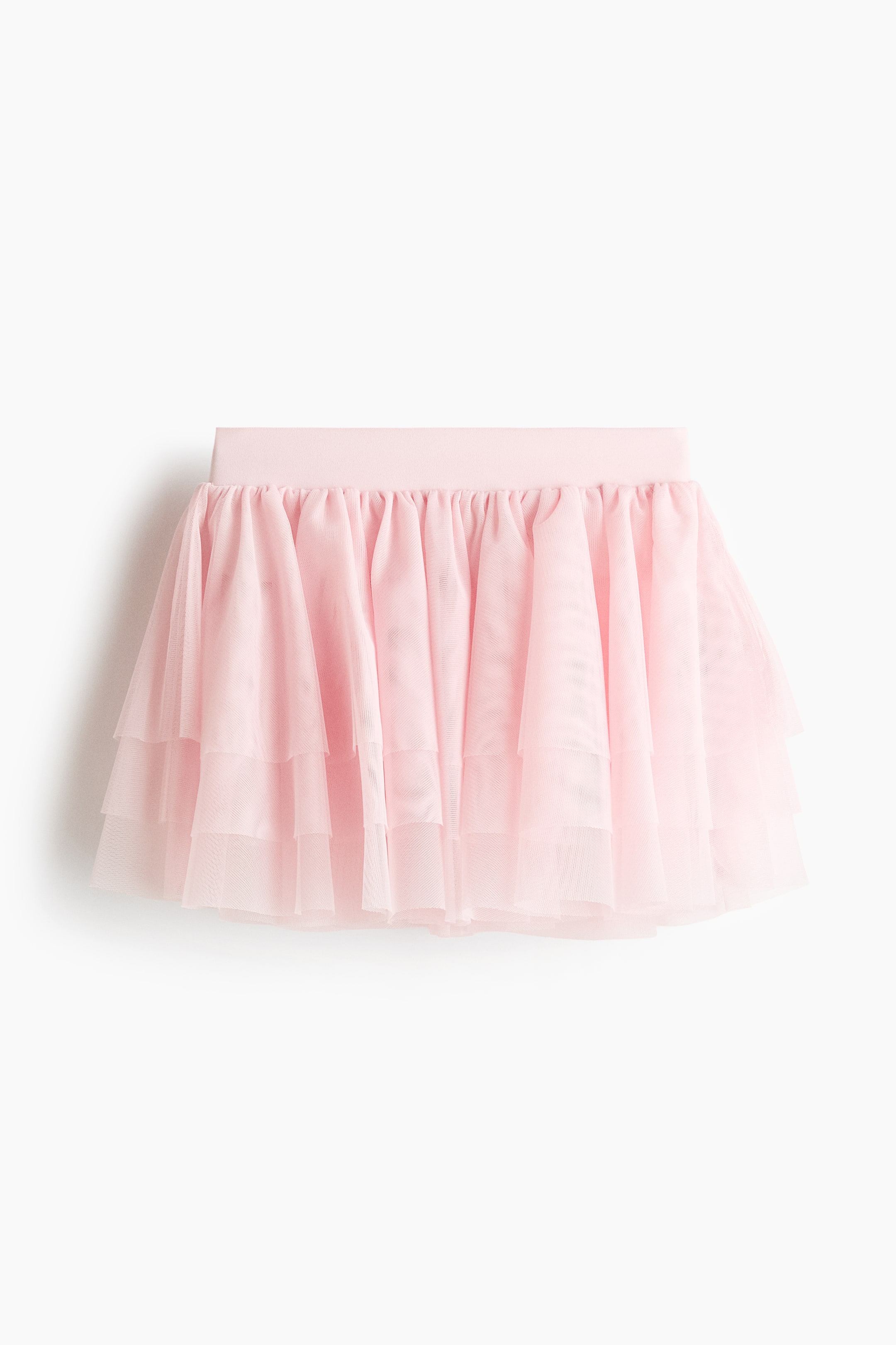 Agrandir l'image: Une jupe tutu rose est présentée de face, avec une large ceinture élastique et plusieurs couches de tulle rose transparent froncées, créant une silhouette volumineuse et à volants.